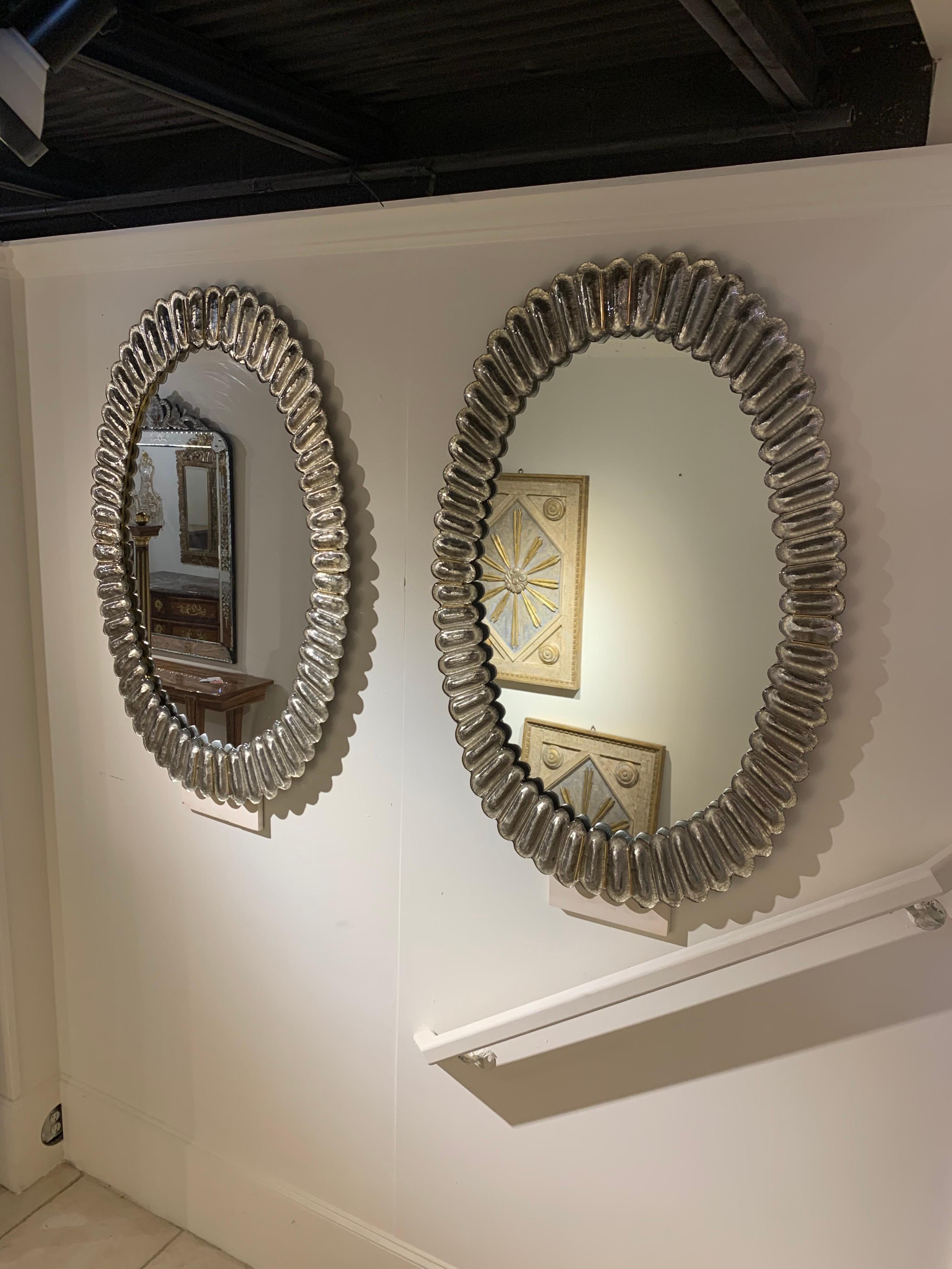 Very fine modern Murano glass oval mirrors with brass trim. Beautiful depth and color to this glass. A fabulous decorative element! Note: Price listed is per item.