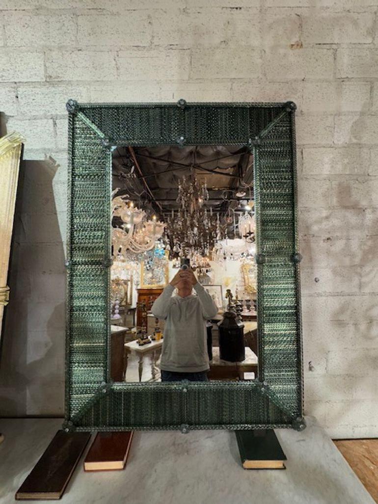 Lo specchio moderno in vetro di Murano Twist in verde scuro presenta un design contemporaneo con un dettaglio di torsione che aggiunge un tocco unico a qualsiasi spazio. Realizzato in vetro di Murano di alta qualità, questo specchio emana eleganza e