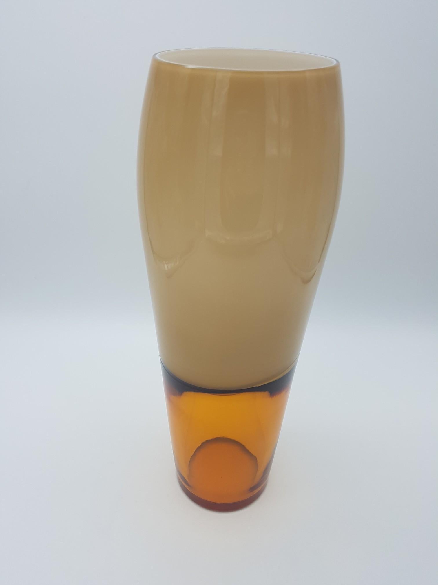 This modern vase, made in the late 1990s by the historical glass-factory Gino Cenedese e Figlio in Murano, is a great example of 'incalmo' glass. This glass-making technique is used to make objects, consisting of distinct parts, by fusing two or