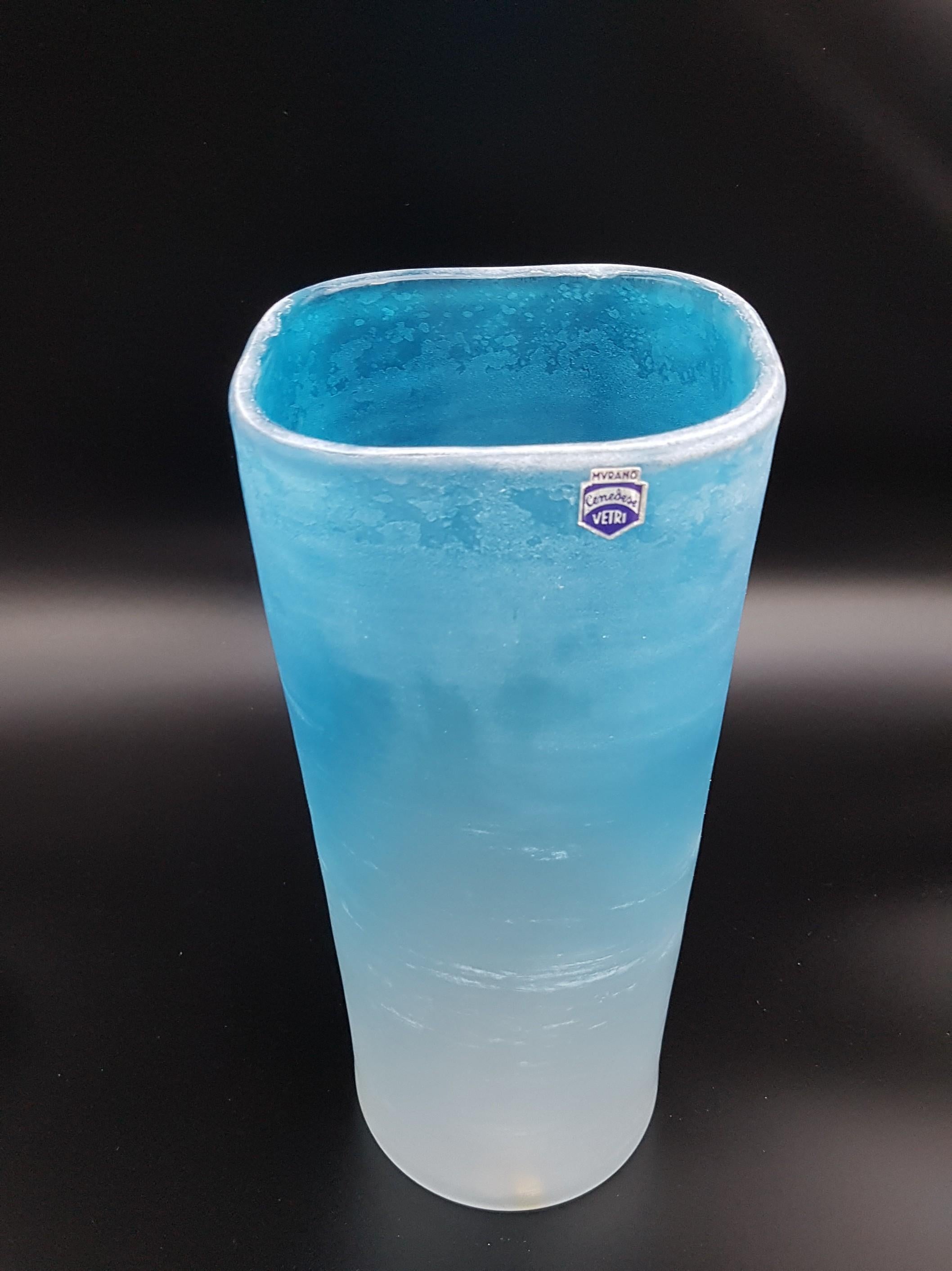 This bright colored Murano glass vase has been completely hand-made in the mid-1980s at the historical Gino Cenedese e Figlio glass-factory. This beautiful vase, 28cm tall, features a brilliant turquoise / sky blue color and a peculiar square
