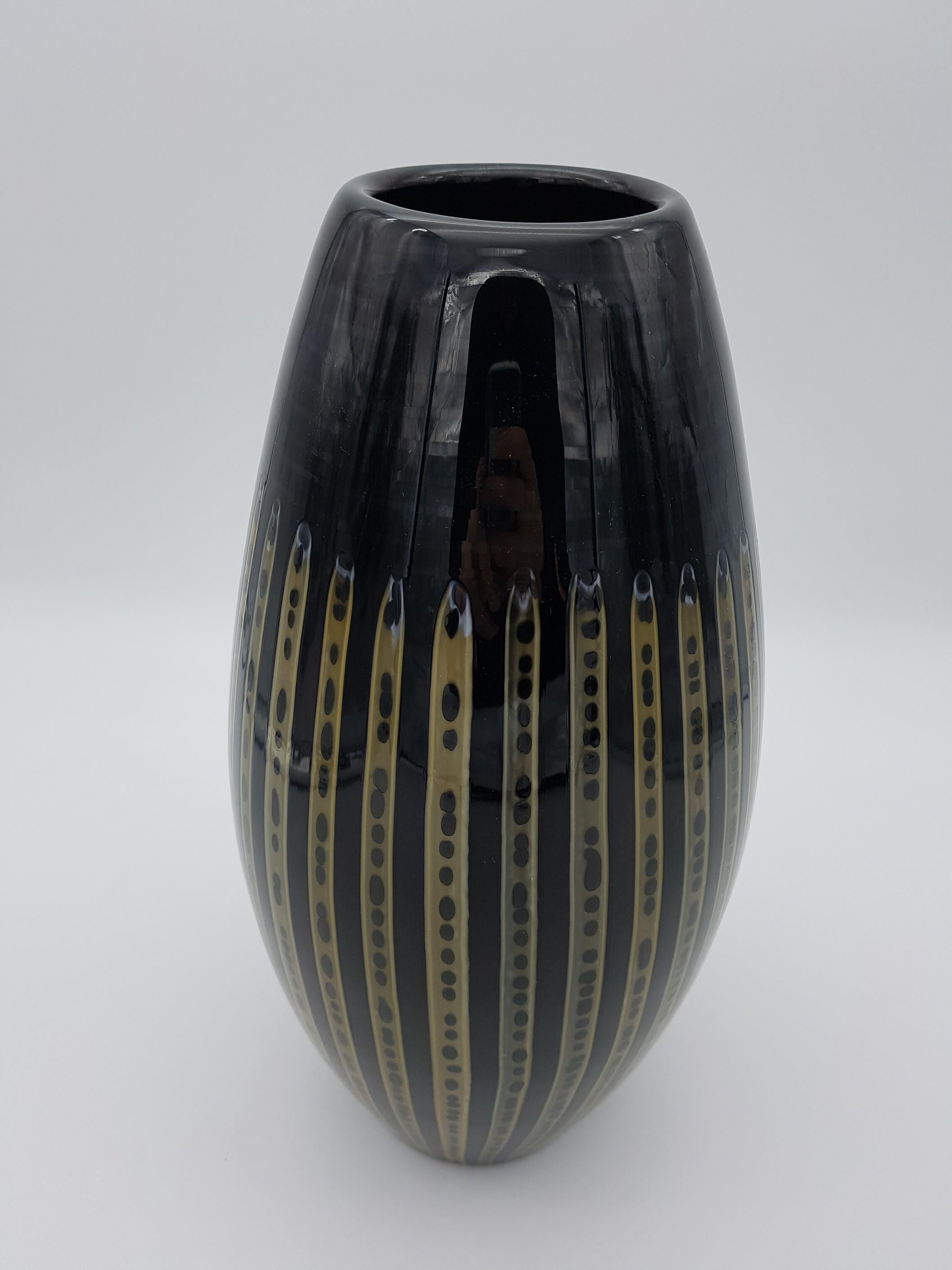 Modern and elegant Murano glass vase, made in the late 1990s by the historical glass-factory Gino Cenedese e Figlio. This beautiful vase is all black color, with vertical yellow glass canes that are the distinctive feature of this piece. The yellow