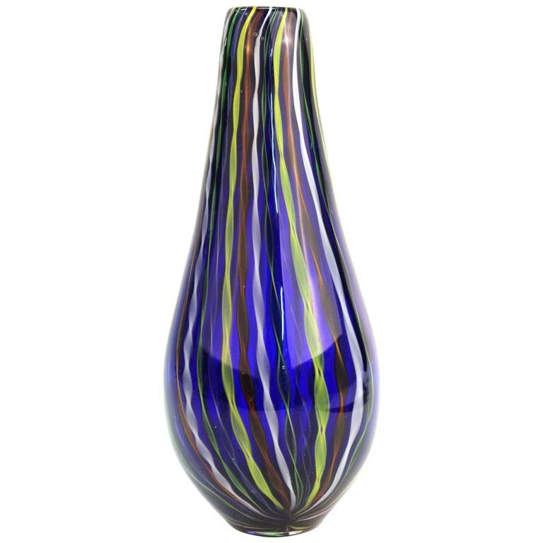 Mid-Century Modern blue art glass vase with multi-color ribbon stripes throughout. Measures: 11.75