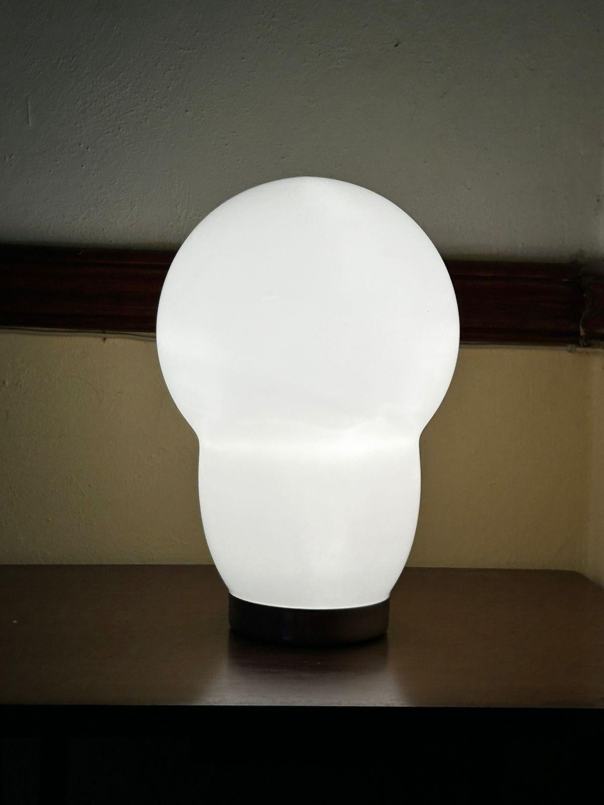 Beautiful table lamp in white hand-blown murano glass.
Designed by Ettore Sottsass for Venini and manufactured in 1994.
The glass shade is signed 