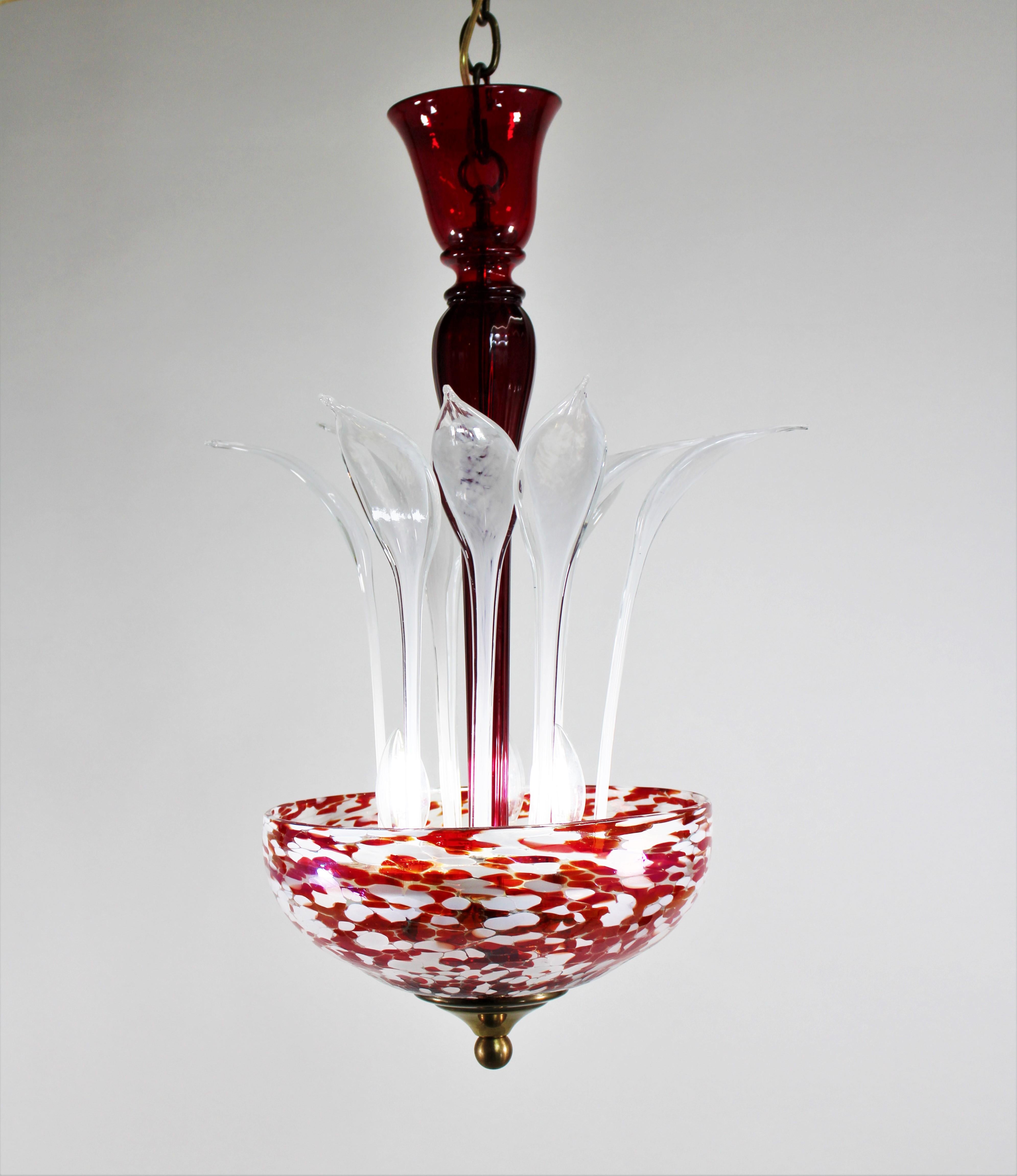 This stunning and unusual modern two-toned Murano ceiling lamp is adorned with beautiful white frond elements, a scarlet red bulbous center column, and a brass finial. The prominent light bowl is speckled with red and white spots formed by rolling