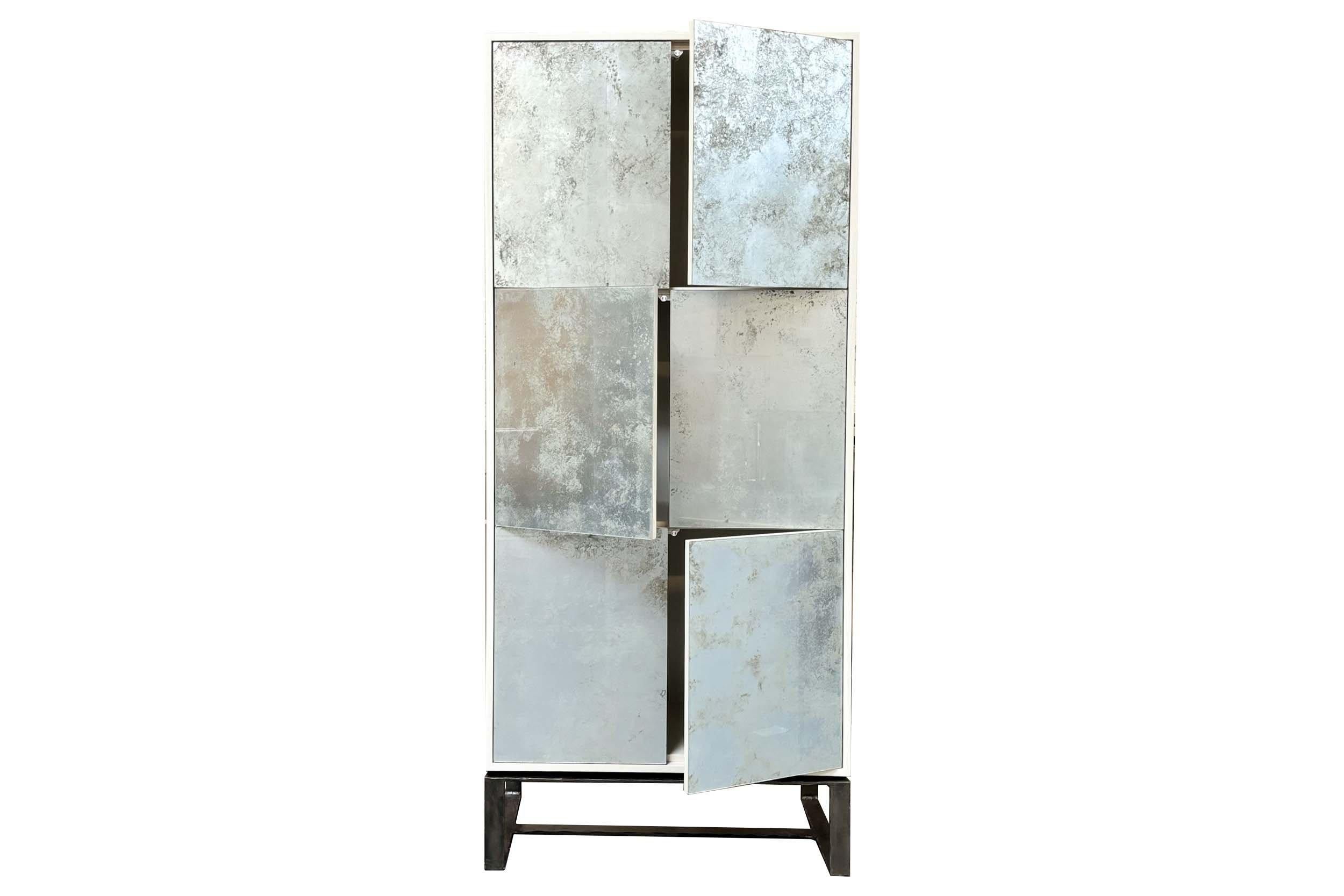The Modern Mystic Six Door Armoire features Six Touch-Latch Doors with panels of hand-painted Mystic Champagne Glass. The body of the piece is Oak with a Sand Finish, and it is raised above a hand-hammered Chelsea style base in a Natural Steel