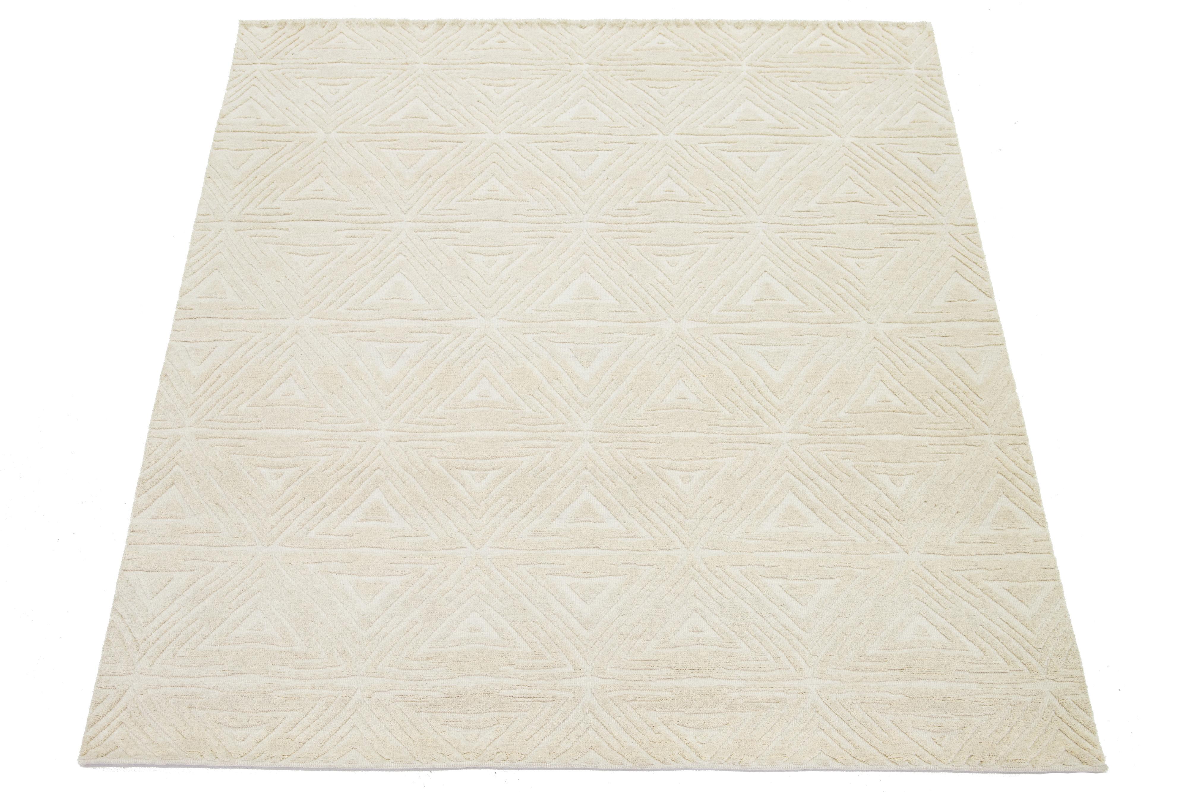 Dieser moderne, handgeknüpfte Wollteppich im marokkanischen Stil hat ein luxuriöses elfenbeinfarbenes Feld und ein kühnes, neutrales, geometrisches Muster.

Dieser Teppich misst 8'2'' x 10'.

 