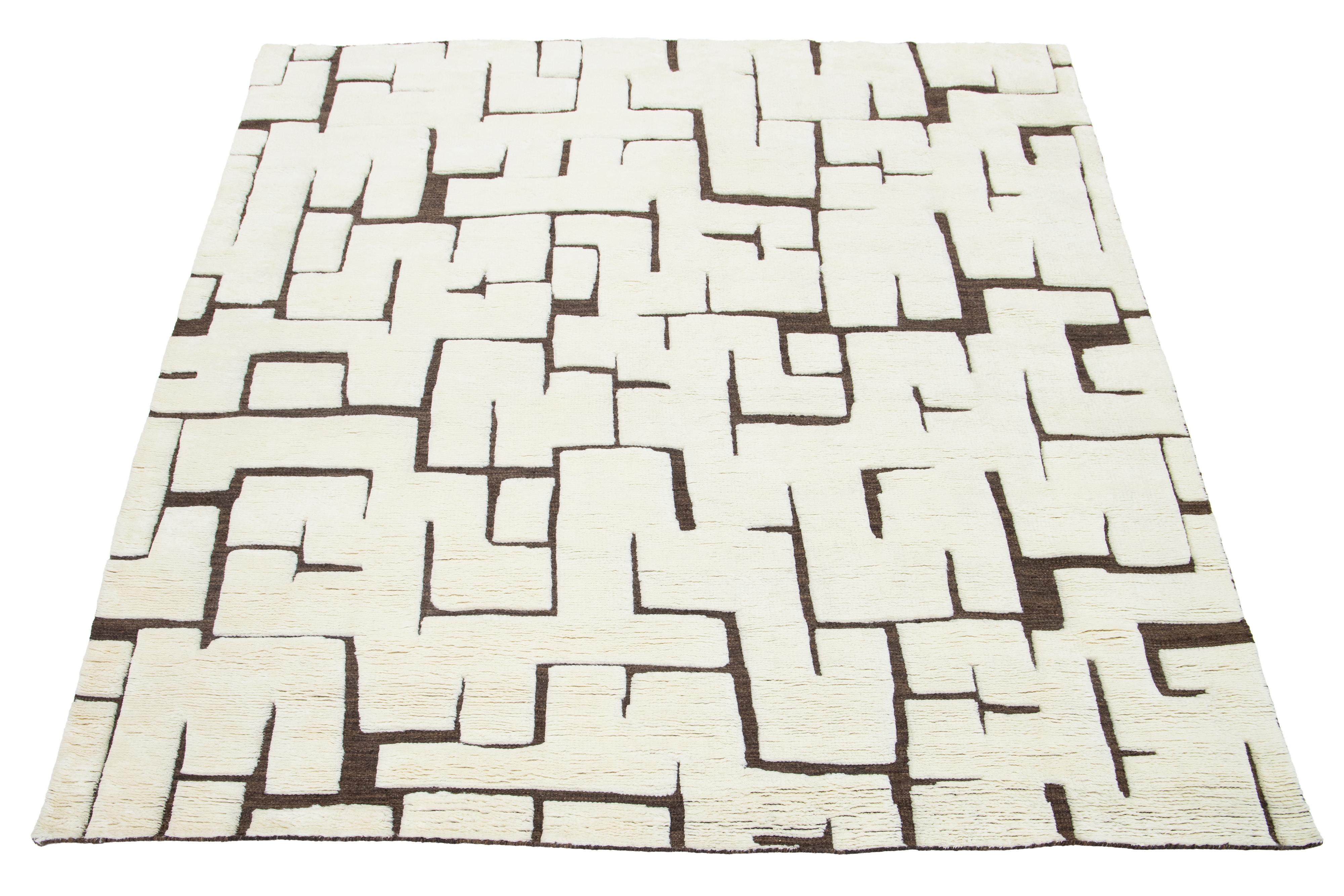 Bellissimo tappeto contemporaneo in lana annodato a mano in stile marocchino con un campo avorio e marrone in uno splendido disegno astratto.

Questo tappeto misura 8' x 9'8