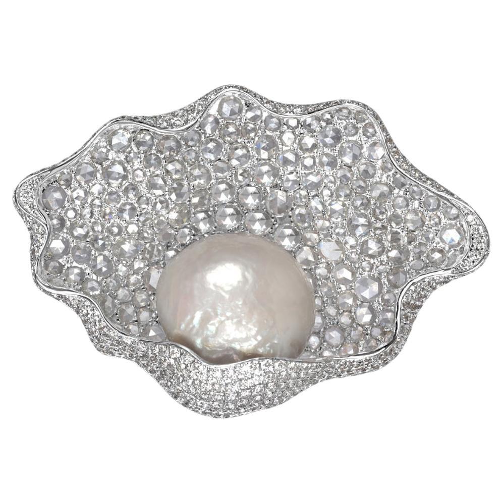
The modern important natural saltwater pearl brooch, mounted in 18kt gold with white rose cut diamonds, is a stunning piece of jewelry that exudes elegance and sophistication. The centerpiece of this exquisite brooch is a natural pearl weighing an