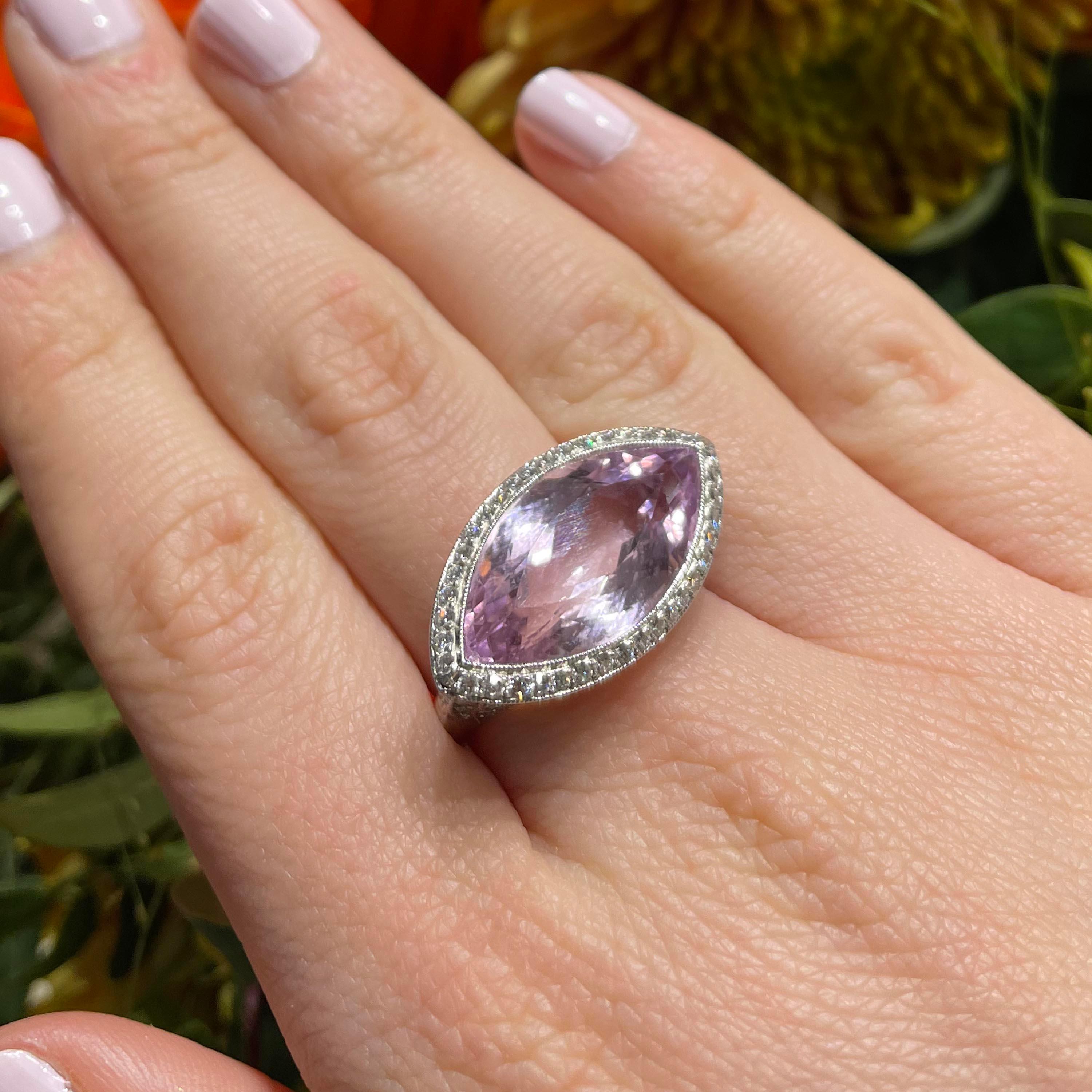 A modern navette kunzite ring, set with a navette-cut kunzite, with a millegrain edged, micro pavé surround, set with round brilliant-cut diamonds, the decorative bezel below is set with three old-cut diamonds on each side, flanked by millegrain