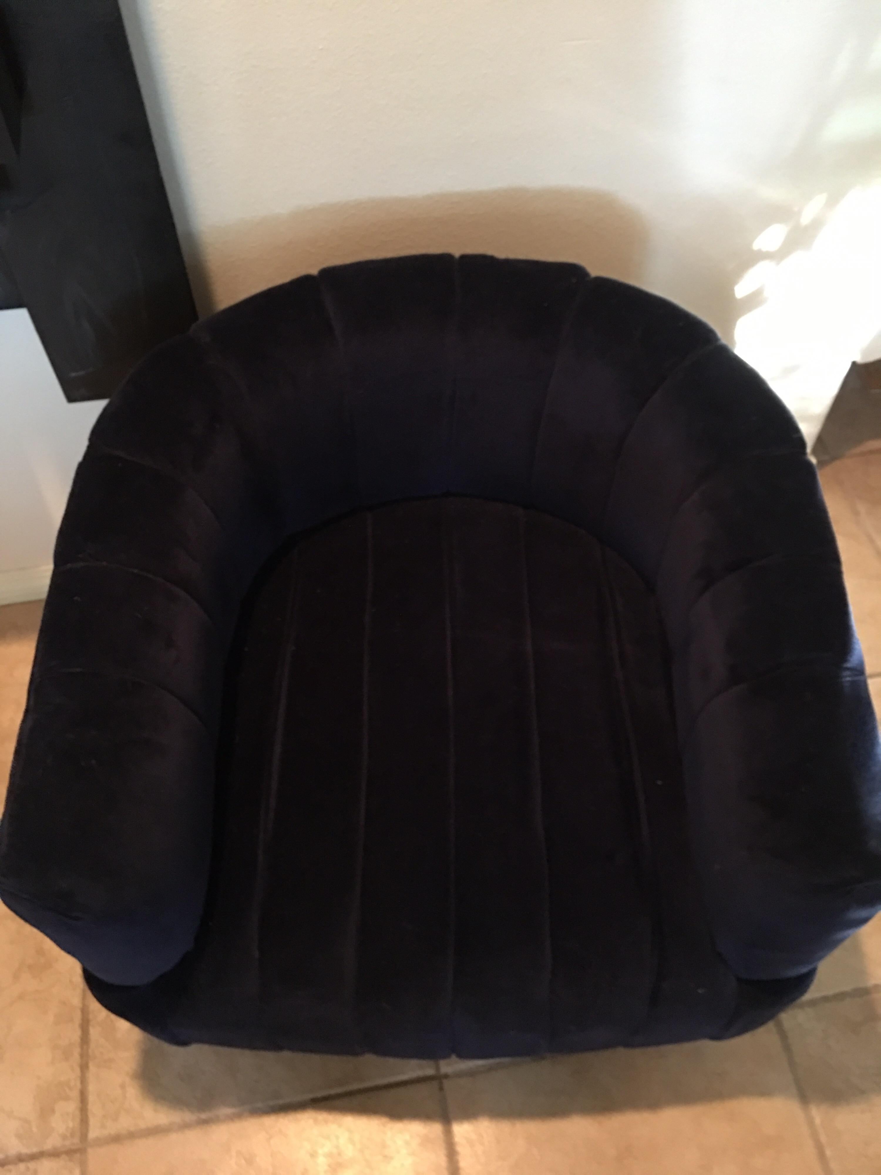 This modern navy velvet chair was purchased to style a residence in Palm Springs. As new. It is a great bedroom or living room chair with channel tufted on seat and inside back. The back of chair is plain velvet. (Not tufted) Antique brass round