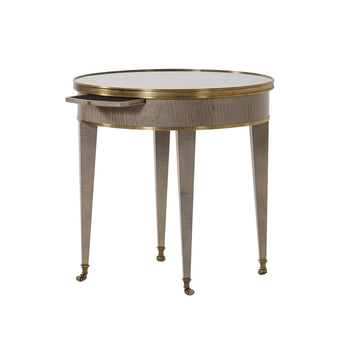 Table d'appoint ronde moderne néo classique. Le style de cette table est inspiré d'une table Bouillotte Louis XVI française du XVIIIe siècle. Il est doté d'un plateau en miroir, d'une glissière pour bougie, d'un temps en laiton, d'un bois exotique