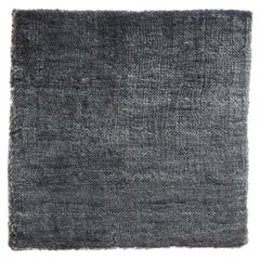 Tappeto minimalista moderno e neutro in seta di bambù, di forma rotonda, di colore blu.