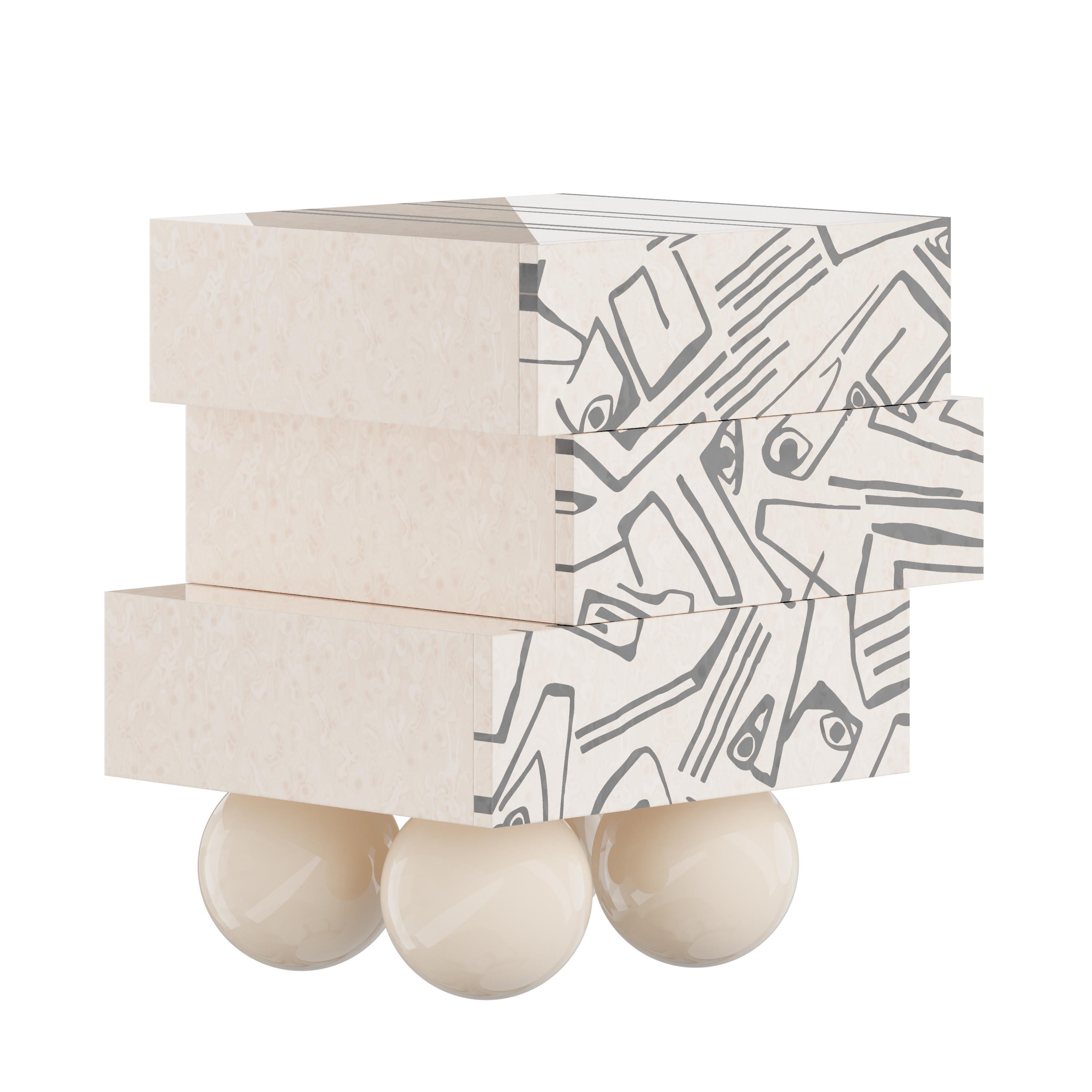 Malaga bedside table is the perfect cubist bedside table for a minimal bedroom project. Its dynamic silhouette features three drawers resting on four legs of wooden spheres. The striking geometric design of this modern nightstand allows it to become