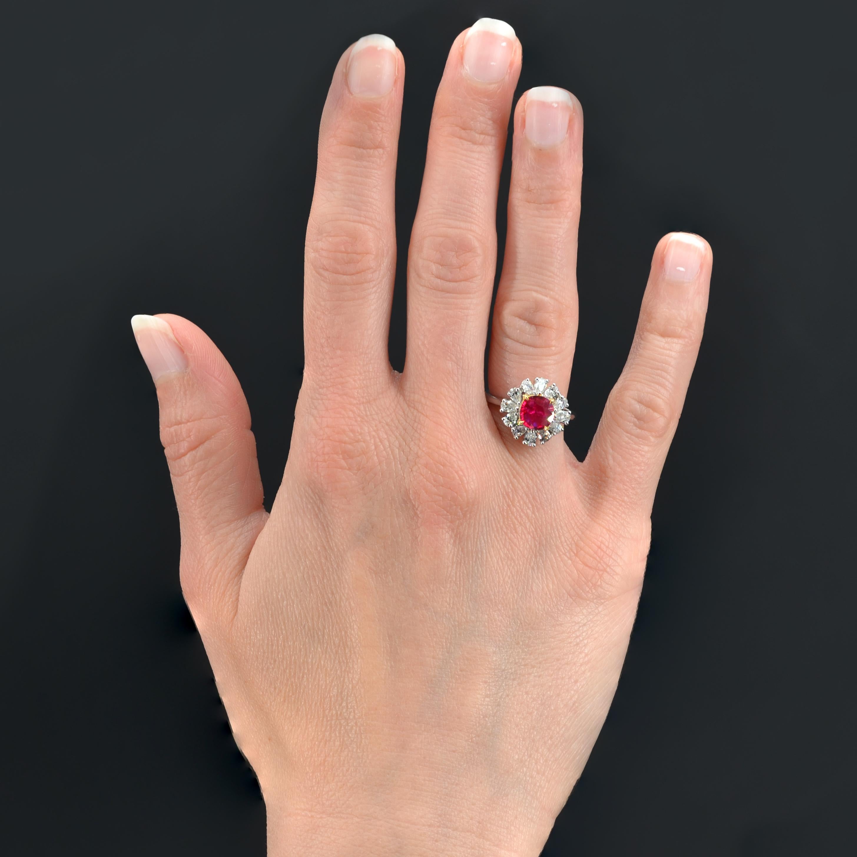 Ring in 18 karat white gold, eagle head hallmark.
Feminine flower ring, it is set with claws of yellow gold on its top, a round ruby in a surround of pear-shaped diamonds also set with claws. The basket is made of gold wire.
Weight of the ruby :