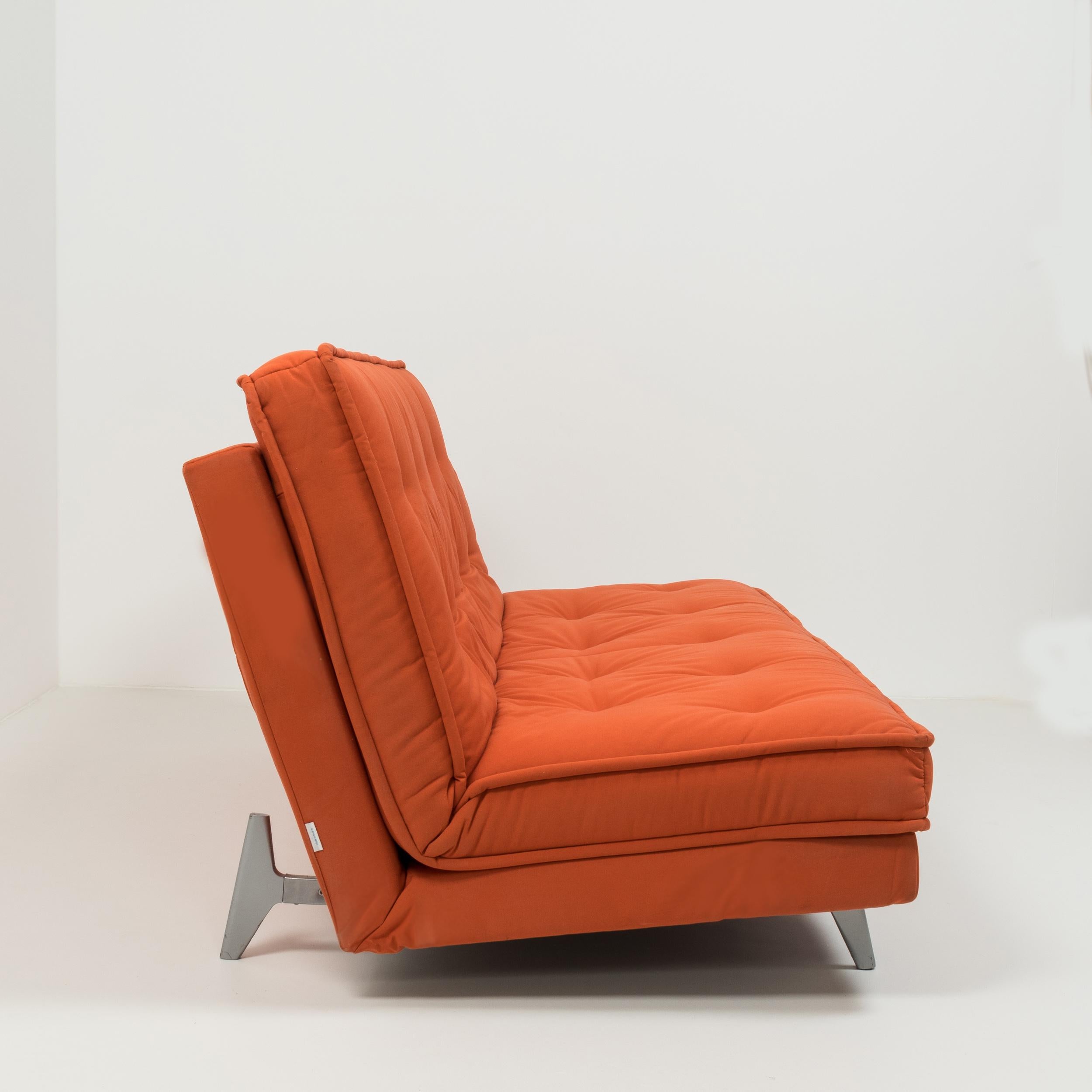 Parfait équilibre entre praticité et style moderne:: ce canapé-lit Nomade Express a été conçu par Didier Gomez pour Linge Roset. 

Composé d'un cadre en acier et d'un seul coussin:: le canapé-lit est tapissé d'un tissu rouge en mélange de coton et