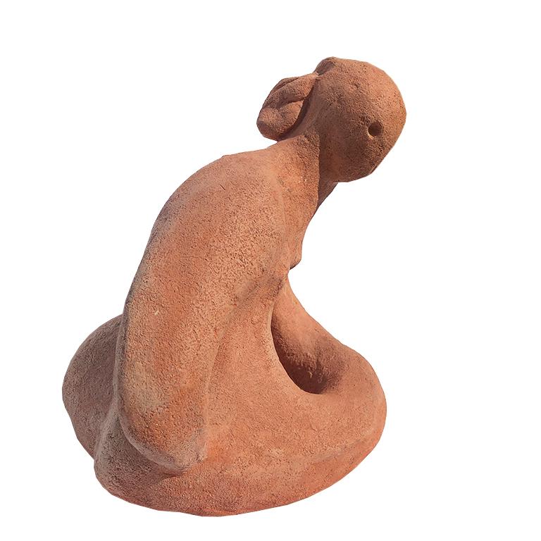 Modern nude terracotta sculpture or figural statue of a Native American man. The piece depicts man sitting with crossed legs, with head turned to his right. The back of the piece shows feather headdress.