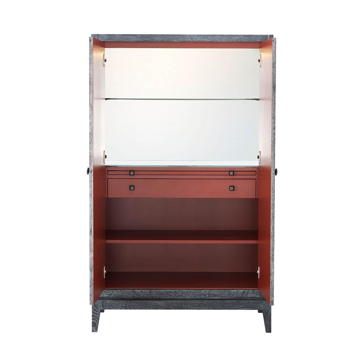 Modern oak bar cabinet with parquetry veneered doors and a cerused finish, with a wild cherry lacquered interior, with a LED-lit mirrored back, a drawer and slide, and an adjustable shelf on splayed tapering oak legs.
Dimensions: 37.5