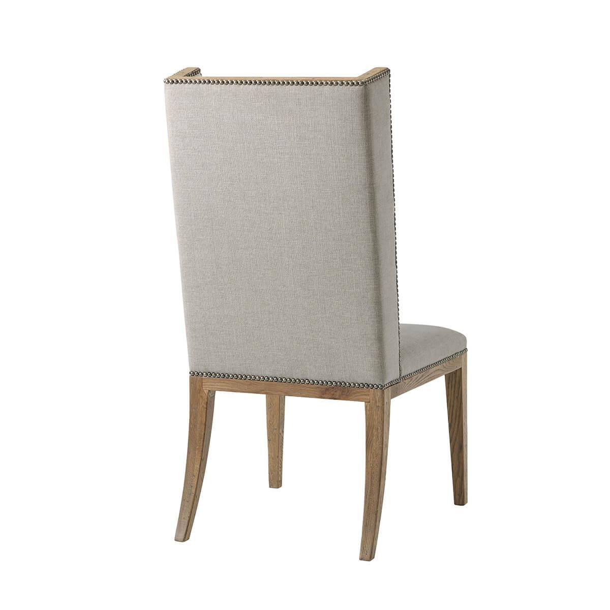 Upholstered Dining Chair in a light echo oak finish frame. The slender winged back and seat are upholstered in performance fabric. Raised on square tapered legs.

Dimensions: 21.5