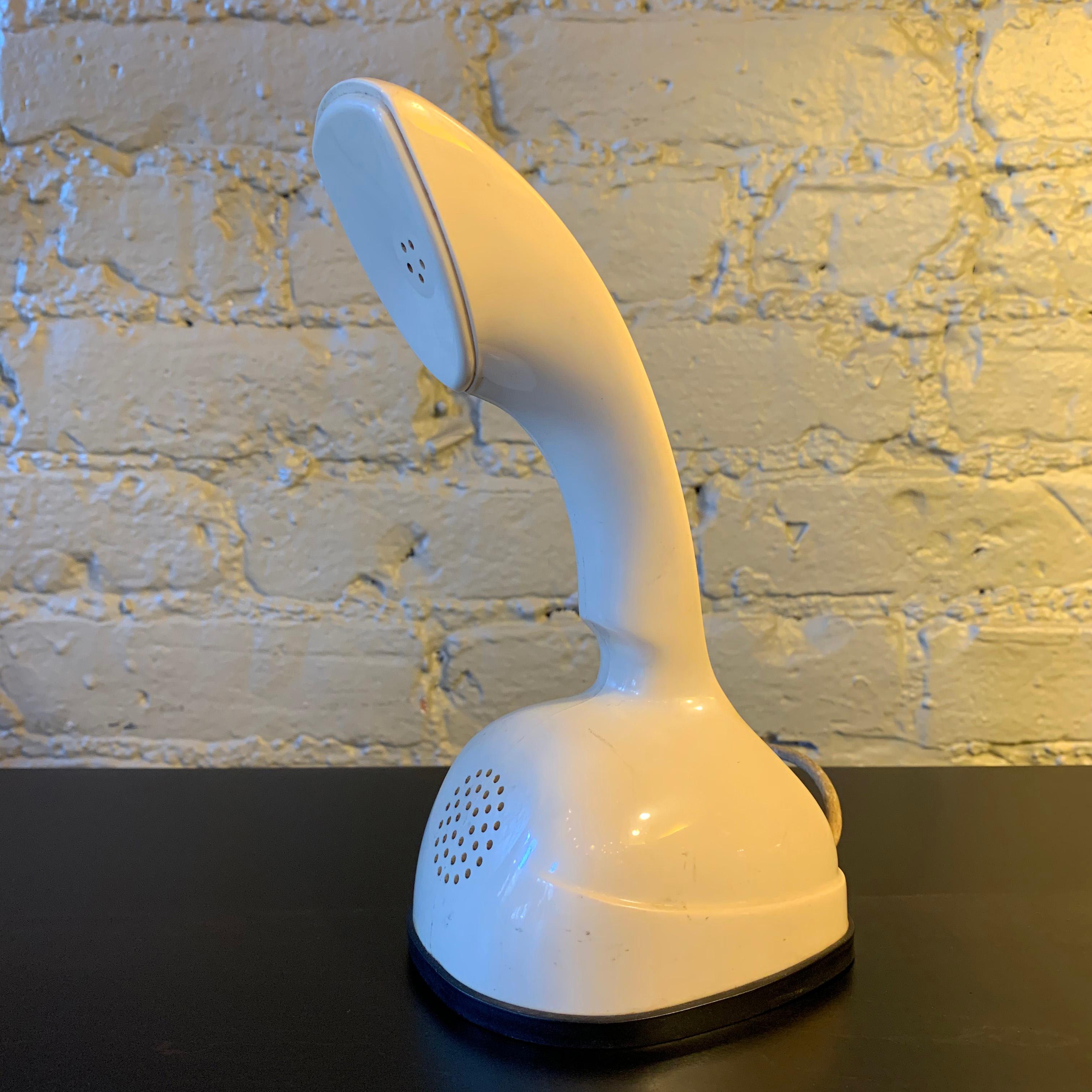 Cream, modern one piece Ericofon telephone created by the Ericsson Company of Sweden and manufactured by North Electric in Galion, Ohio features a rotary dial on the bottom. Due to its styling and its influence on future telephone design, the