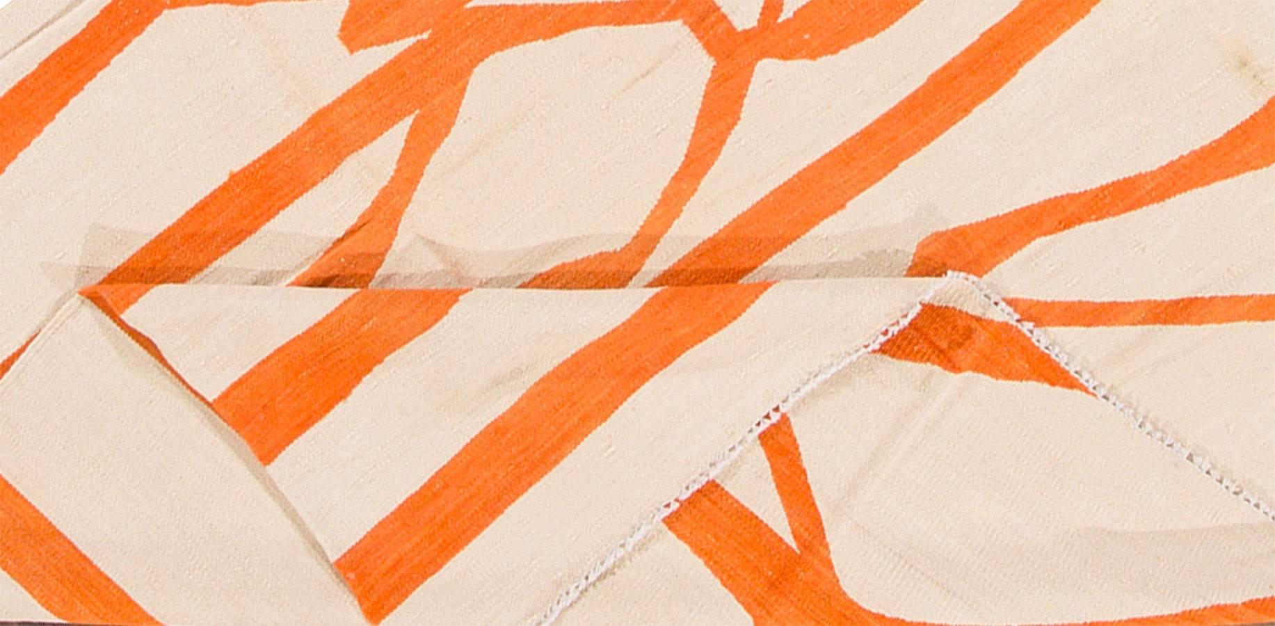 Moderner handgewebter türkischer Kilim-Teppich mit ikonischem und abstraktem orangefarbenem Streifendesign auf einem cremefarbenen Feld. Misst ungefähr 7 Fuß 10 Zoll mal 9 Fuß 8 Zoll.
