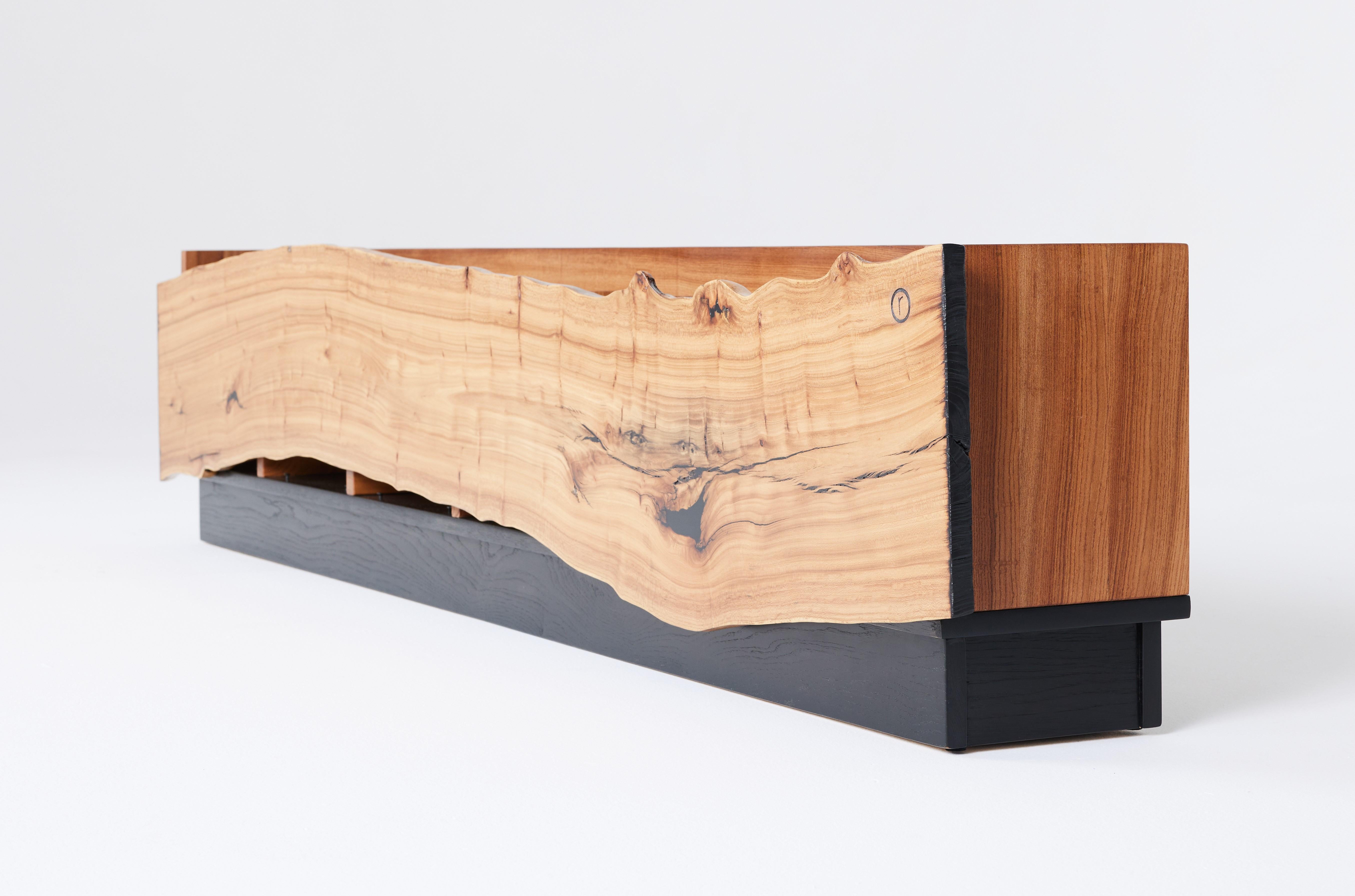 Diese moderne, organische Plattenkonsole von Carlo Stenta ist aus mehreren Ulmenholzplatten gefertigt, die aus einer einzigen Ulme gefräst wurden. Die Schallplattenkonsole verfügt über kunstvoll gefertigte Trennwände, die genau bemessen sind, so