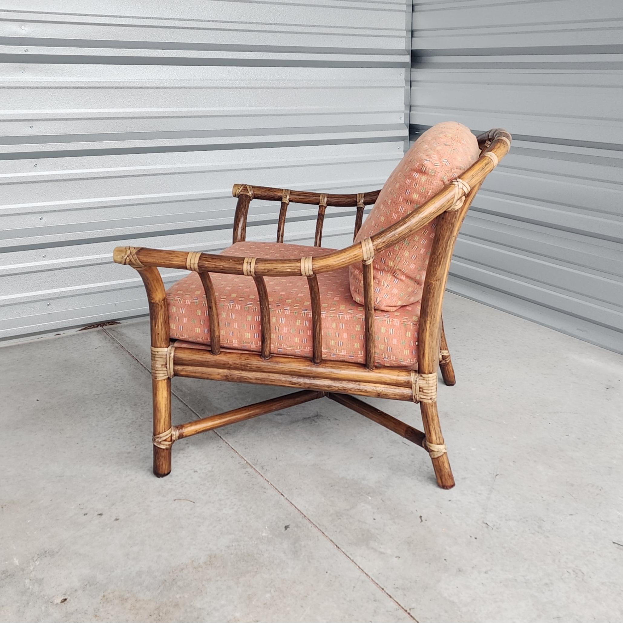 Gorgeous oversized bent rattan lounge chair made in the California organic modern coastal style by McGuire. This chair features a large horseshoe shaped bent rattan frame with gracefully curved supports. The finish is a lovely darker walnut in color