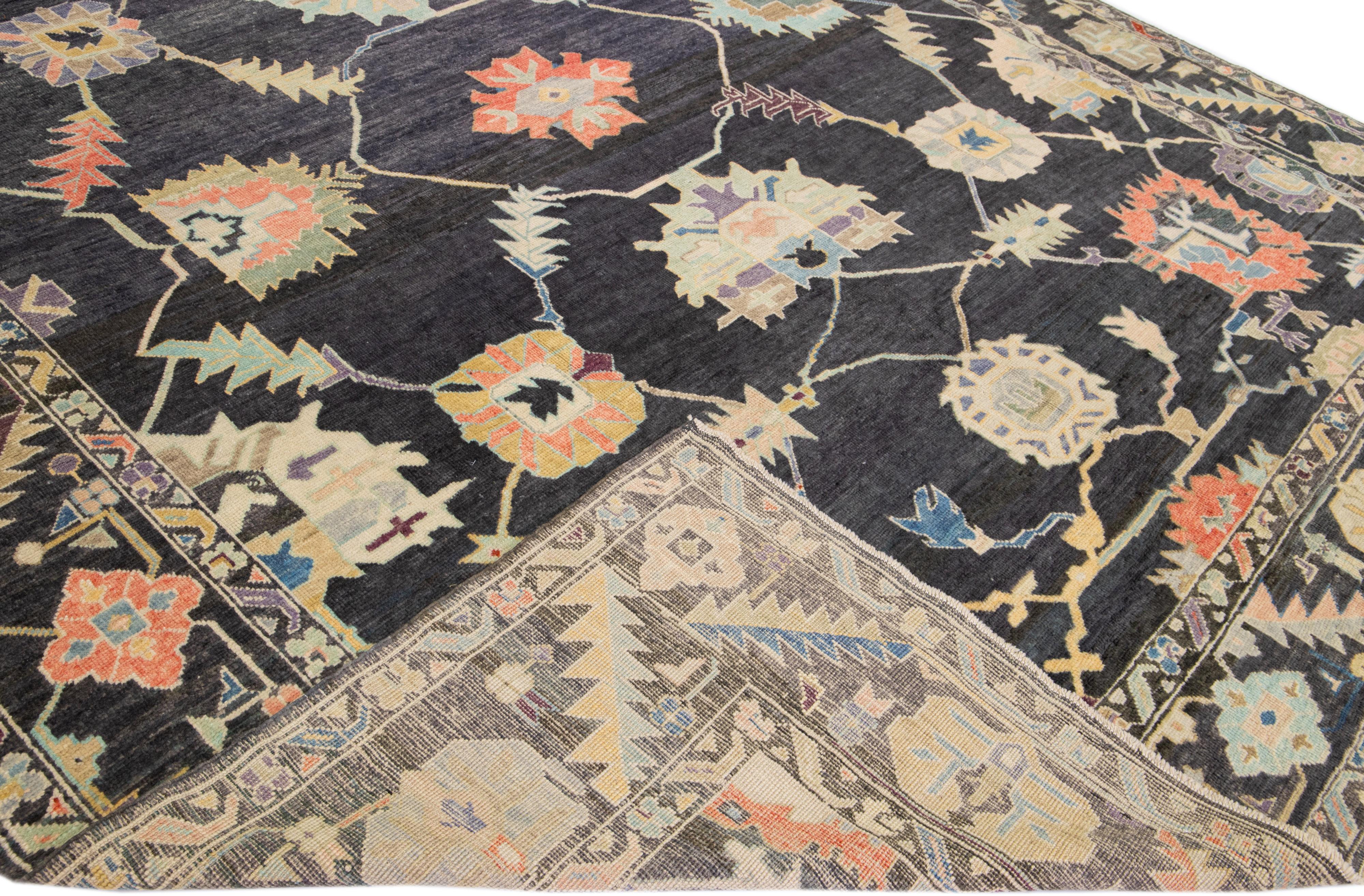 Beautiful modern Oushak hand-knotted wool rug with a charcoal field. This Turkish rug has a designed frame with multicolor accents in a gorgeous all-over floral design.

This rug measures: 12'2