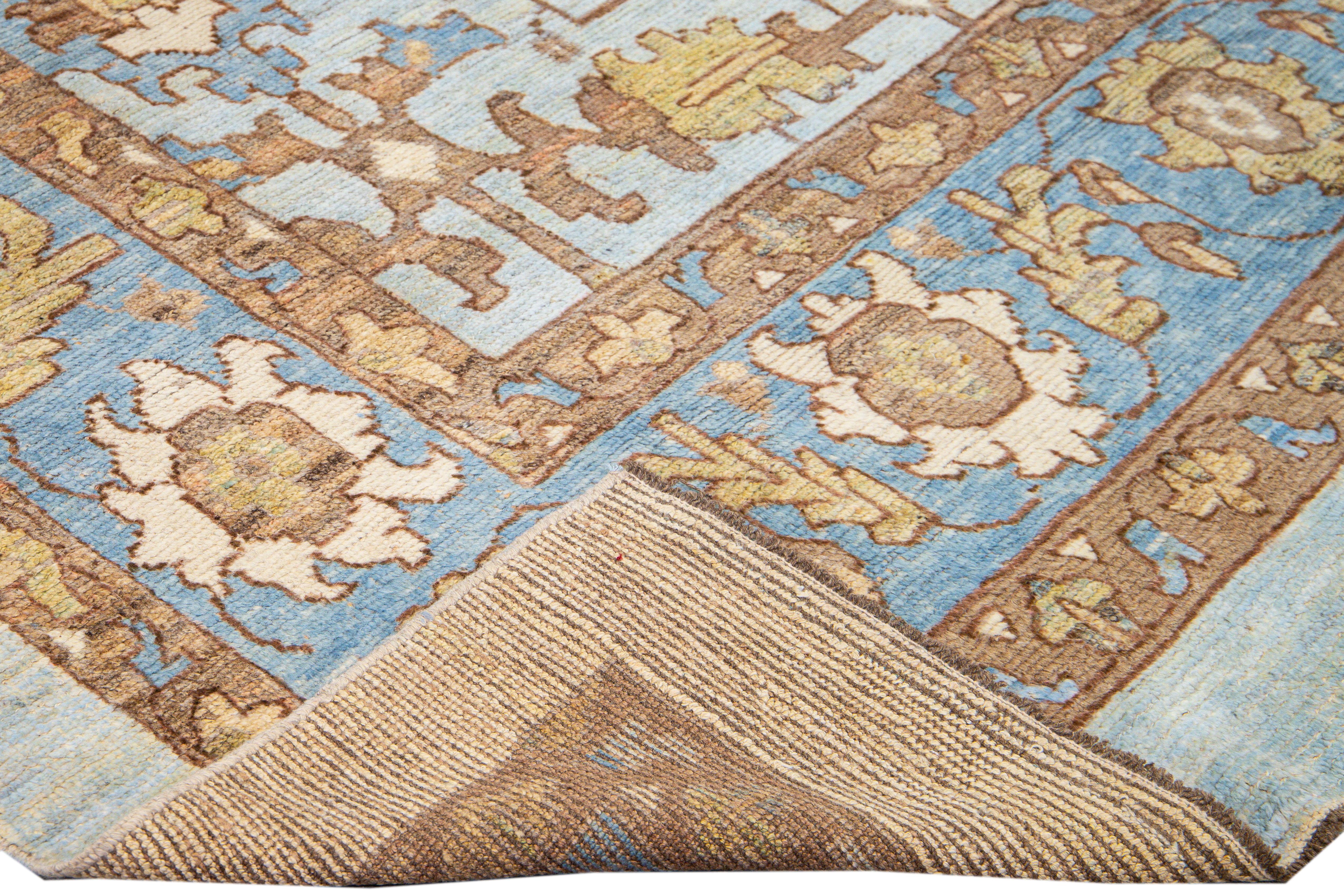 Beautiful modern Oushak hand-knotted wool rug with a blue field. This Oushak rug has goldenrod, blue, and brown accents all over a gorgeous geometric tribal floral design. 

This rug measures: 12'8