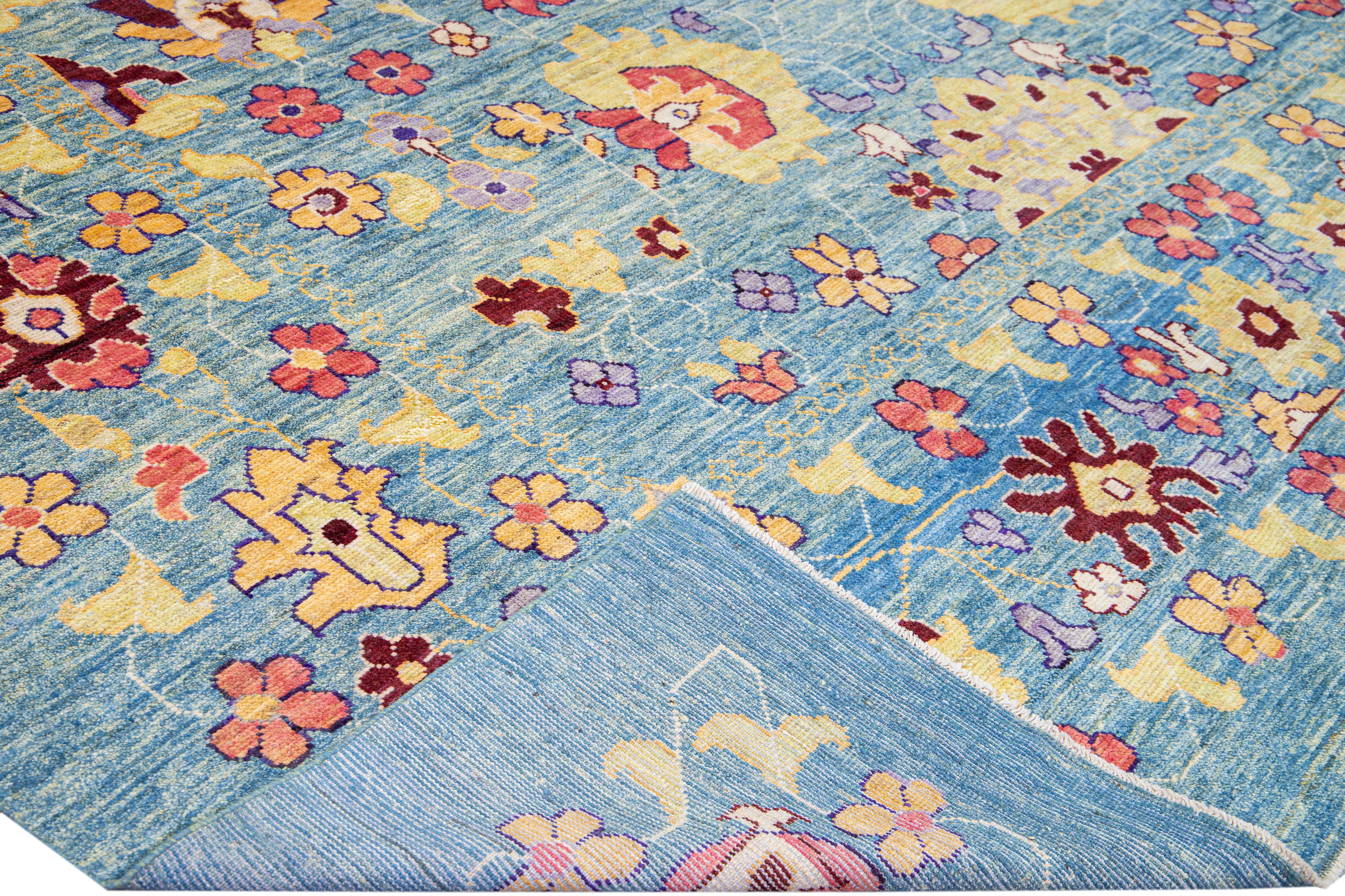 Beautiful modern Oushak hand-knotted wool rug with a blue field. This Oushak rug has a multicolor accents layout a gorgeous geometric floral pattern design. 

This rug measures: 11'8