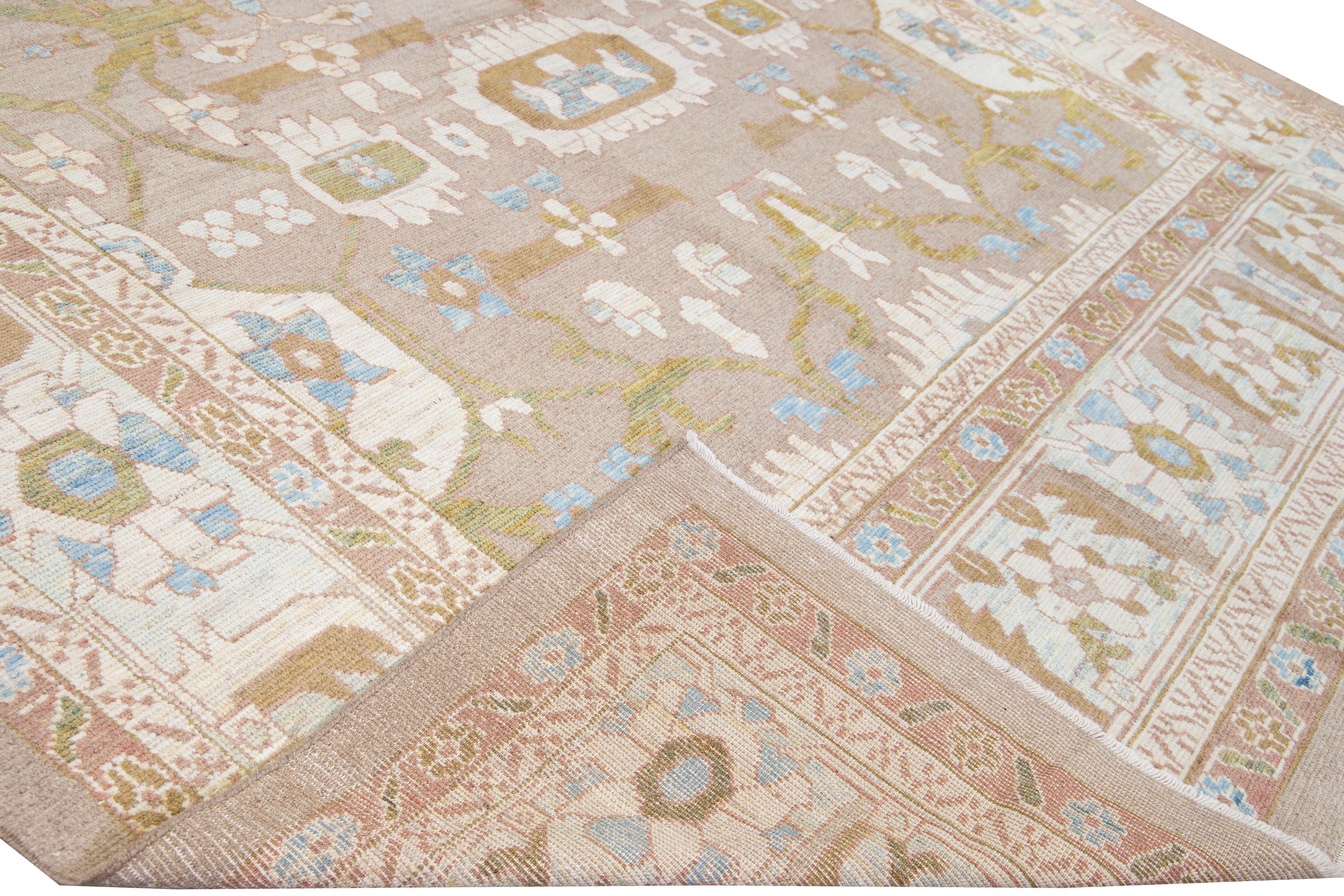 Beautiful Modern Oushak hand-knotted wool rug with a brown field. This Oushak rug has a beige frame and ivory, green, pink, and yellow accents layout a gorgeous botanical floral motif. 

This rug measures: 10'10