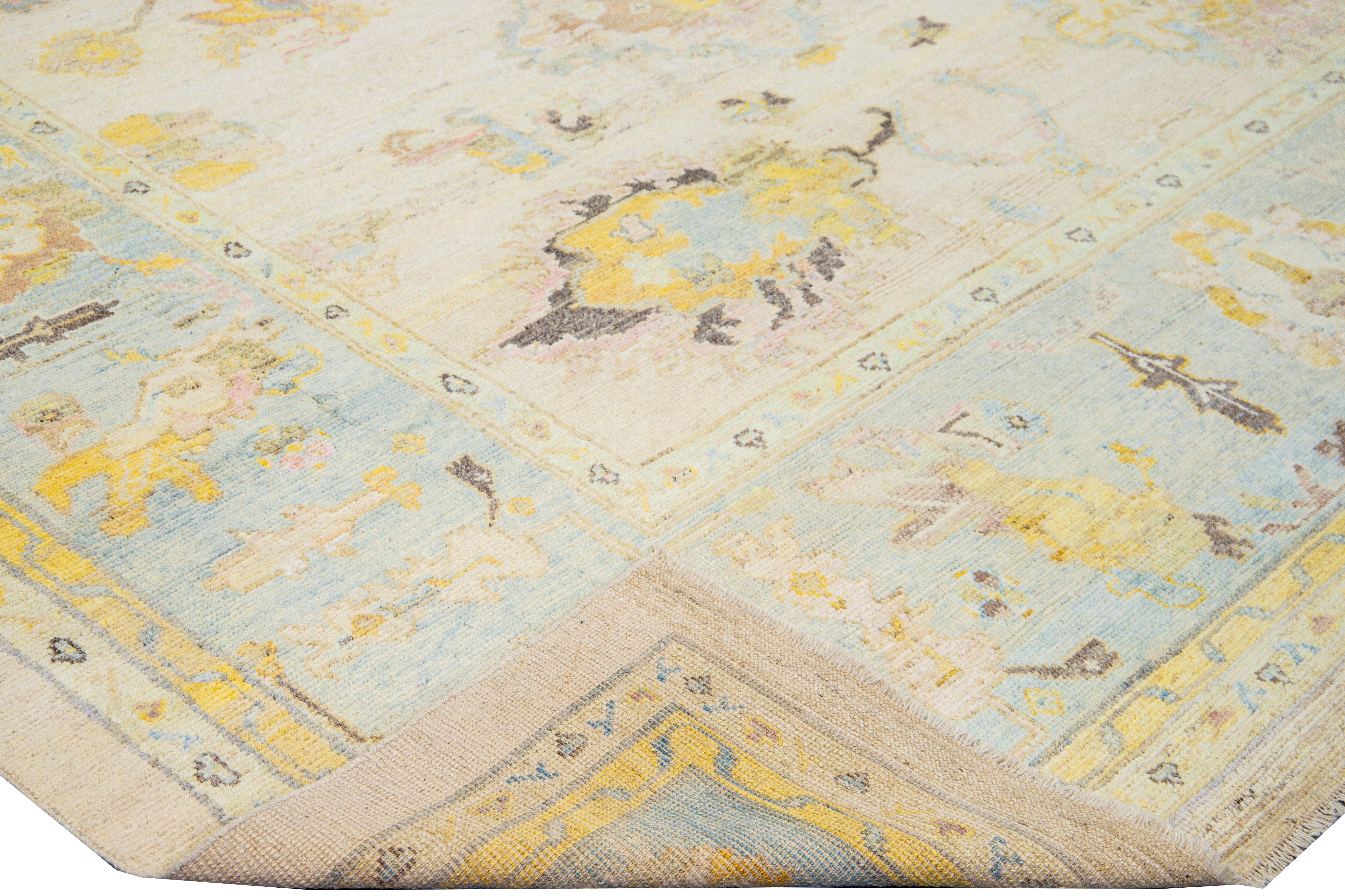 Beautiful modern Oushak hand-knotted wool rug with a yellow field. This Oushak rug has a blue frame and yellow, gray, and pink accents layout a gorgeous tribal floral design. 

This rug measures: 10'7