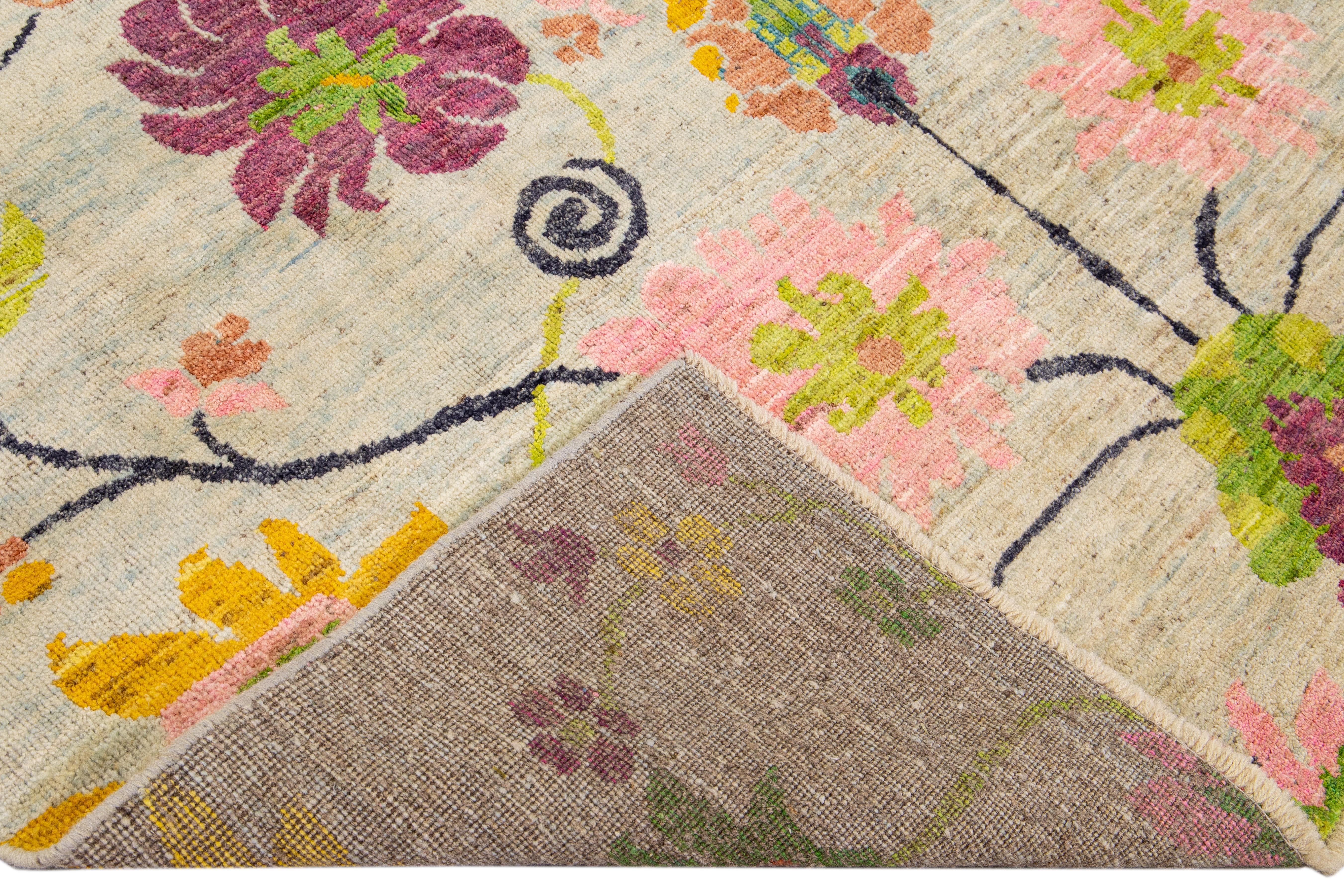 Beautiful modern Oushak hand-knotted wool rug with a beige field. This Oushak rug has a purple, pink, green, and blue accents layout a gorgeous geometric floral pattern design. 

This rug measures: 7' x 10'.

Our rugs are professional cleaning