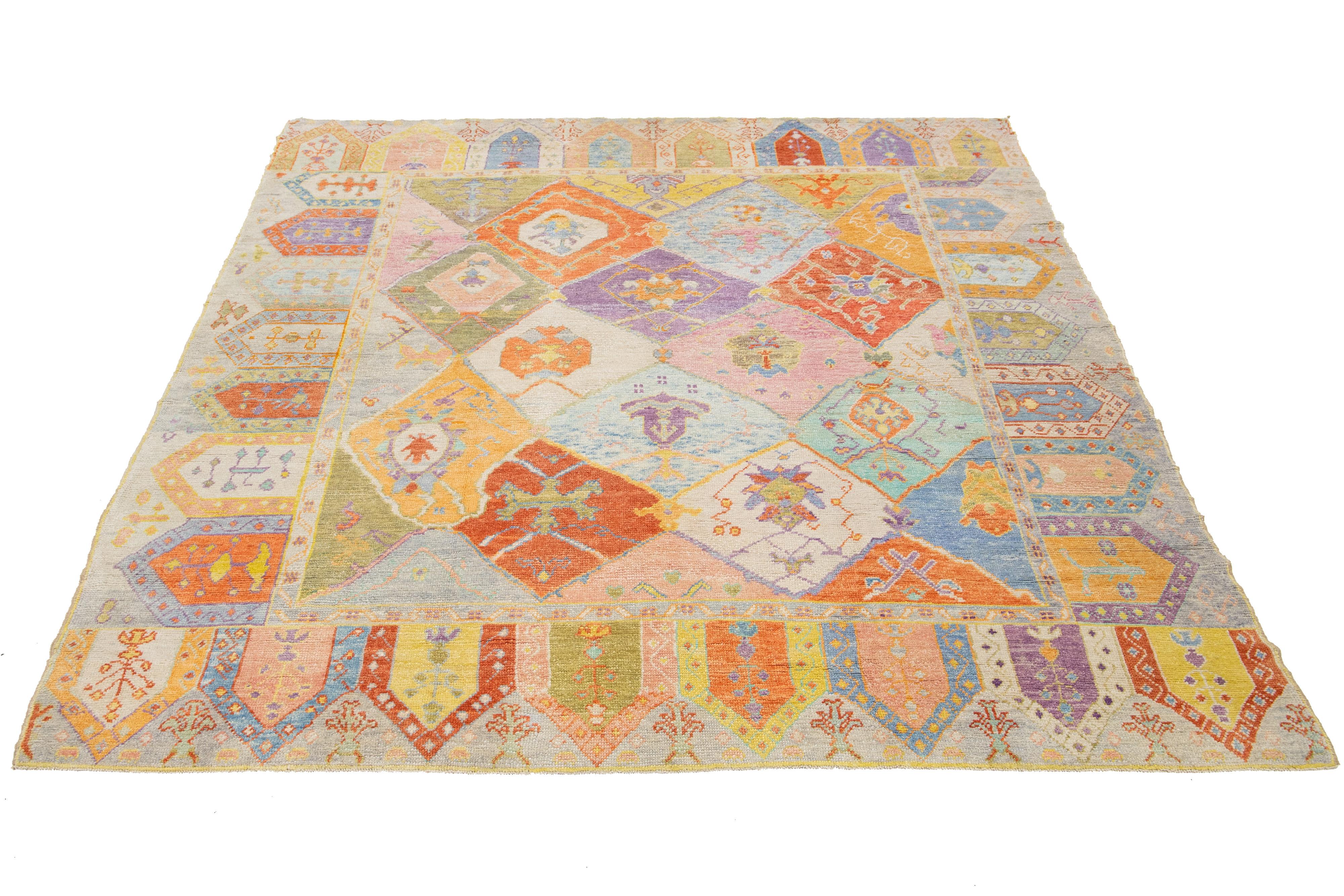 Esta impresionante y moderna alfombra Oushak está anudada a mano con suave lana y presenta un vibrante campo multicolor. Adornada con un exquisito estampado floral geométrico integral, esta pieza destaca en cualquier espacio.

Esta alfombra mide
