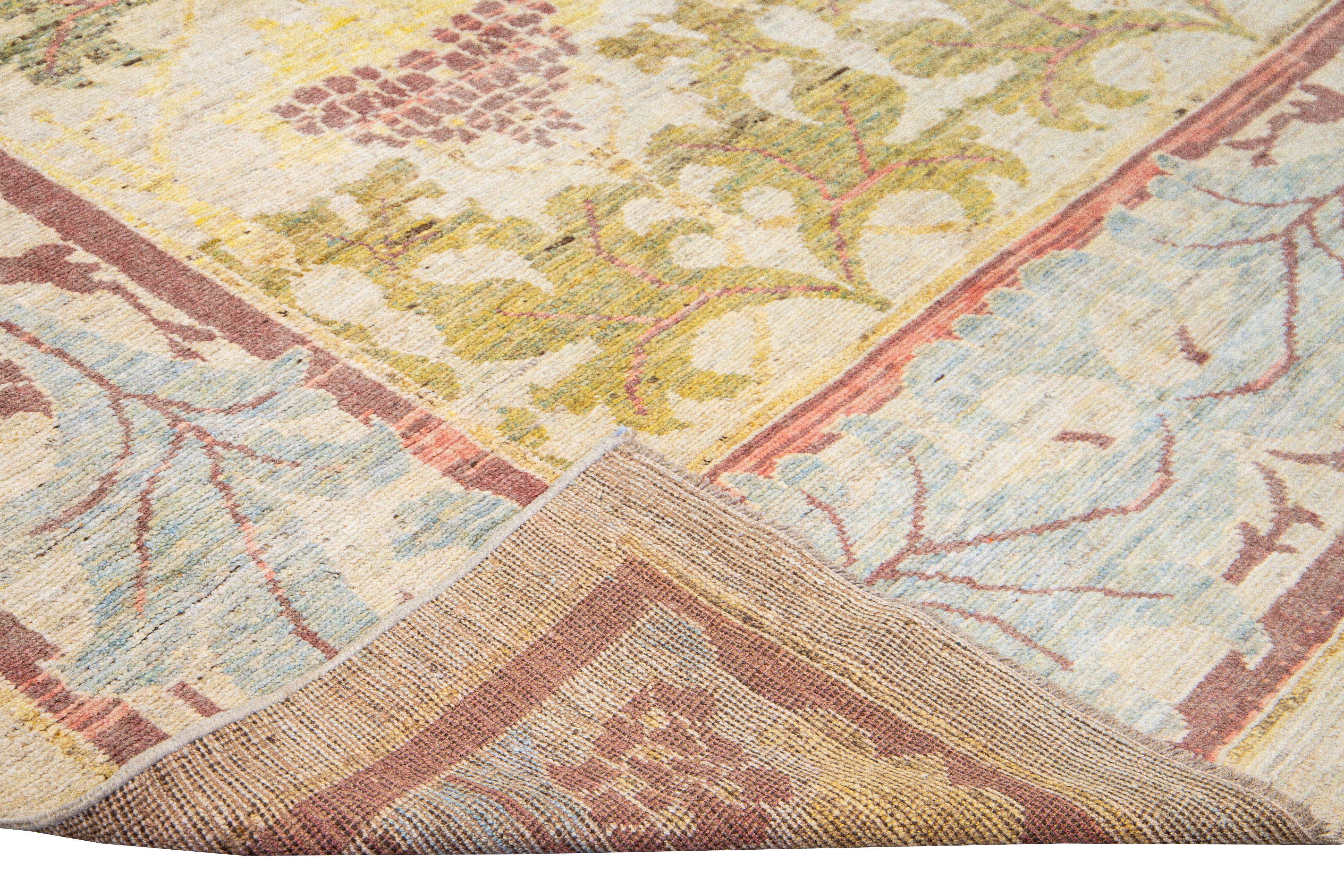 Beautiful modern Oushak hand-knotted wool rug with a blue and beige field. This Oushak rug has pink, blue, and brown accents in gorgeous vine scroll and a palmettes design. 

This rug measures: 10'10