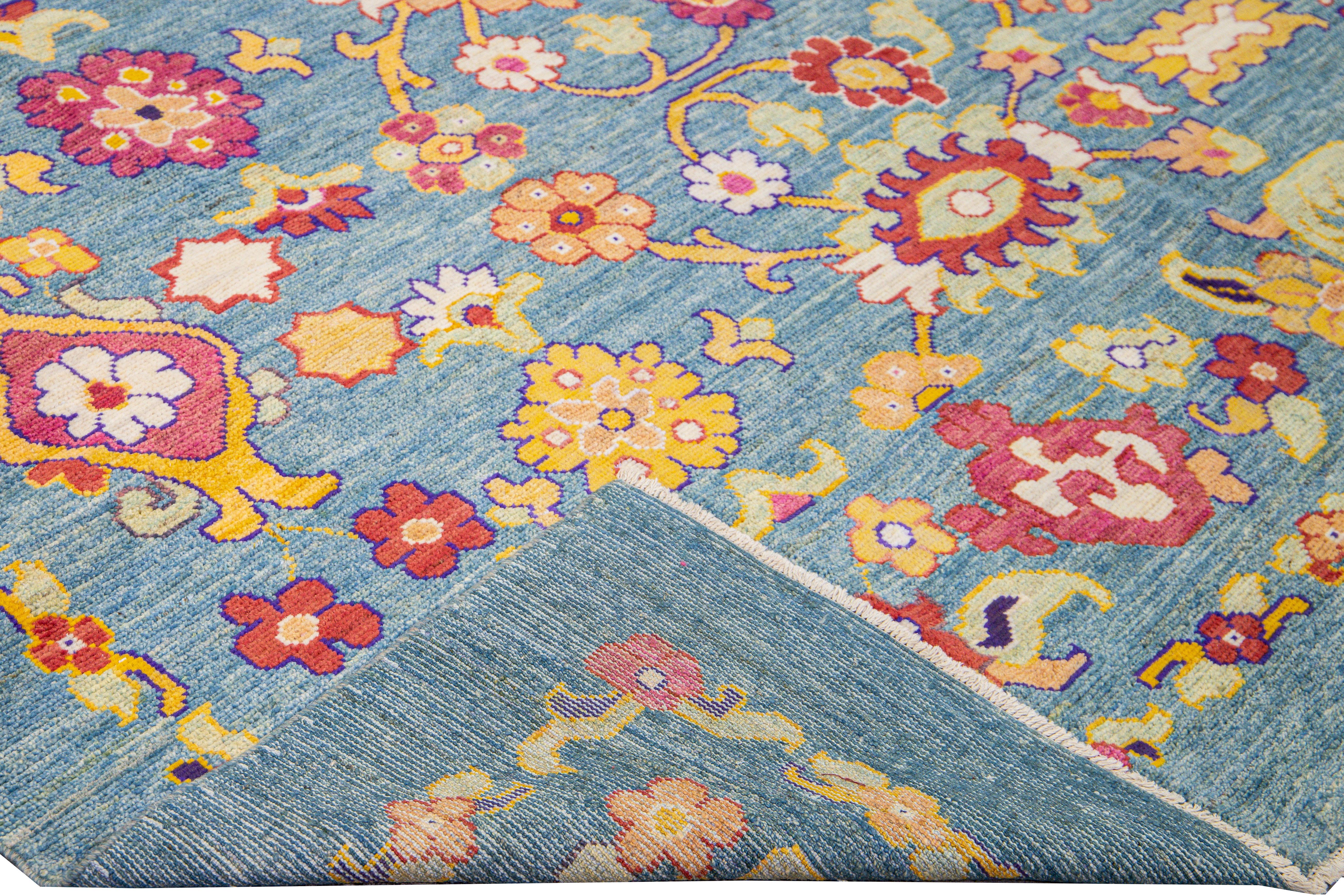 Beautiful modern Oushak hand-knotted wool rug with a blue field. This Oushak rug has multicolor accents in a gorgeous Tribal floral pattern design. 

This rug measures: 11'9