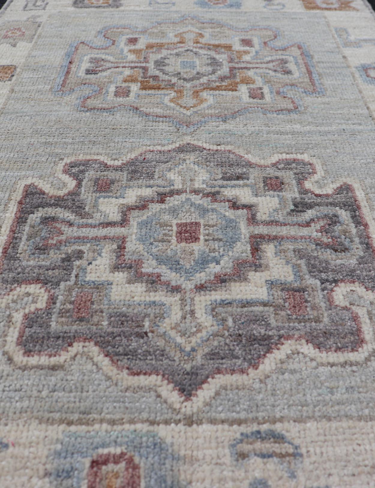 Motifs modernes de médaillons Oushak sur fond gris clair et tons terreux. Keivan Woven Arts ; tapis AWR-16044 Pays d'origine : Afghanistan Type : Oushak Design/One.
Mesures : 2'0 x 3'2 
La bordure et le champ sont couverts de motifs floraux remplis