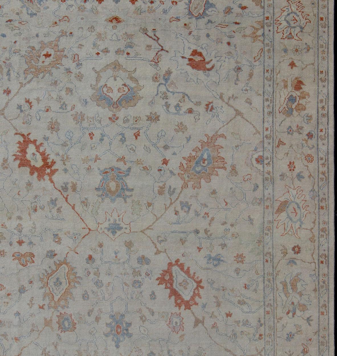  Oushak rug with blue and coral, neutral color palette and all-over flower design, rug BDH-742274, country of origin / type: India/ Oushak

This hand knotted Oushak rug features a beautiful design rendered in blue and coral and multicolored