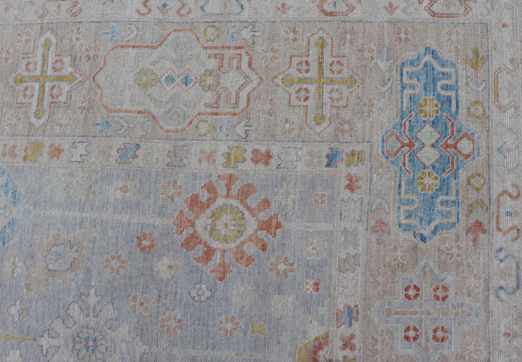 Modern Oushak rug hand knotted on a light gray field and rusty orange. Keivan Woven Arts; rug AWR-3719 Country of Origin: Afghanistan Type: Oushak Design: Mosaic Floral, 

The border and field are covered in floral-like motifs filled with colors