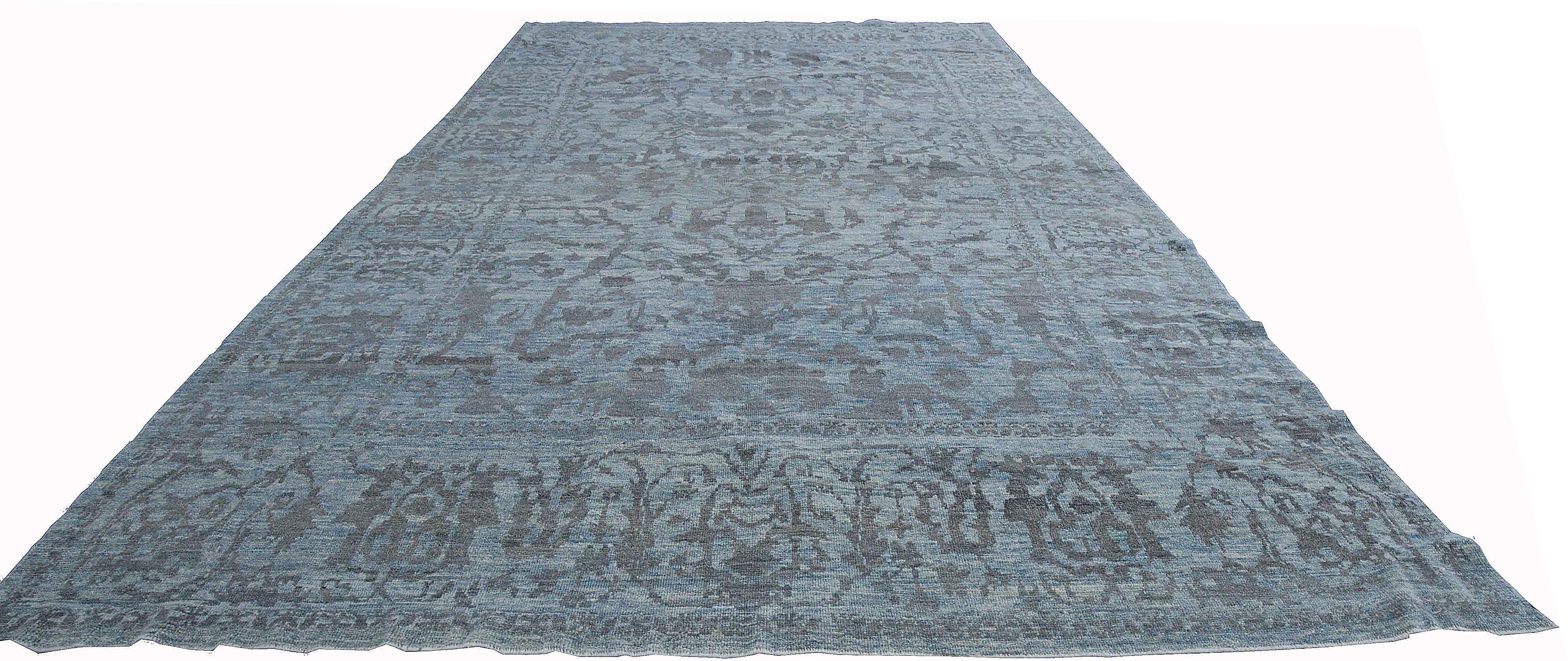 Modern Turkish rug made of handwoven sheep’s wool of the finest quality. It’s colored with organic vegetable dyes that are certified safe for humans and pets alike. It features a lovely blue field with floral details in gray commonly identified with