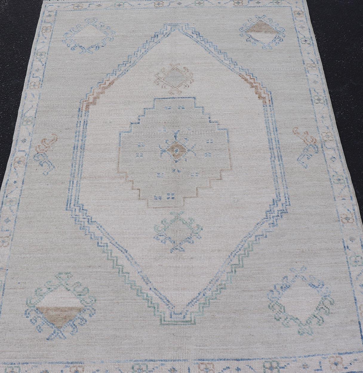 Maße: 4'1 x 6'0 
Moderner Oushak-Teppich mit weicher grauer Basis und Akzenten in Blau, Taupe und 4'1 x 6'0. Keivan Woven Arts. Teppich /AWR-511/ Frühes 21. Jahrhundert, Türkischer Oushak.

Dieser moderne Oushak-Teppich hat ein wunderschönes,