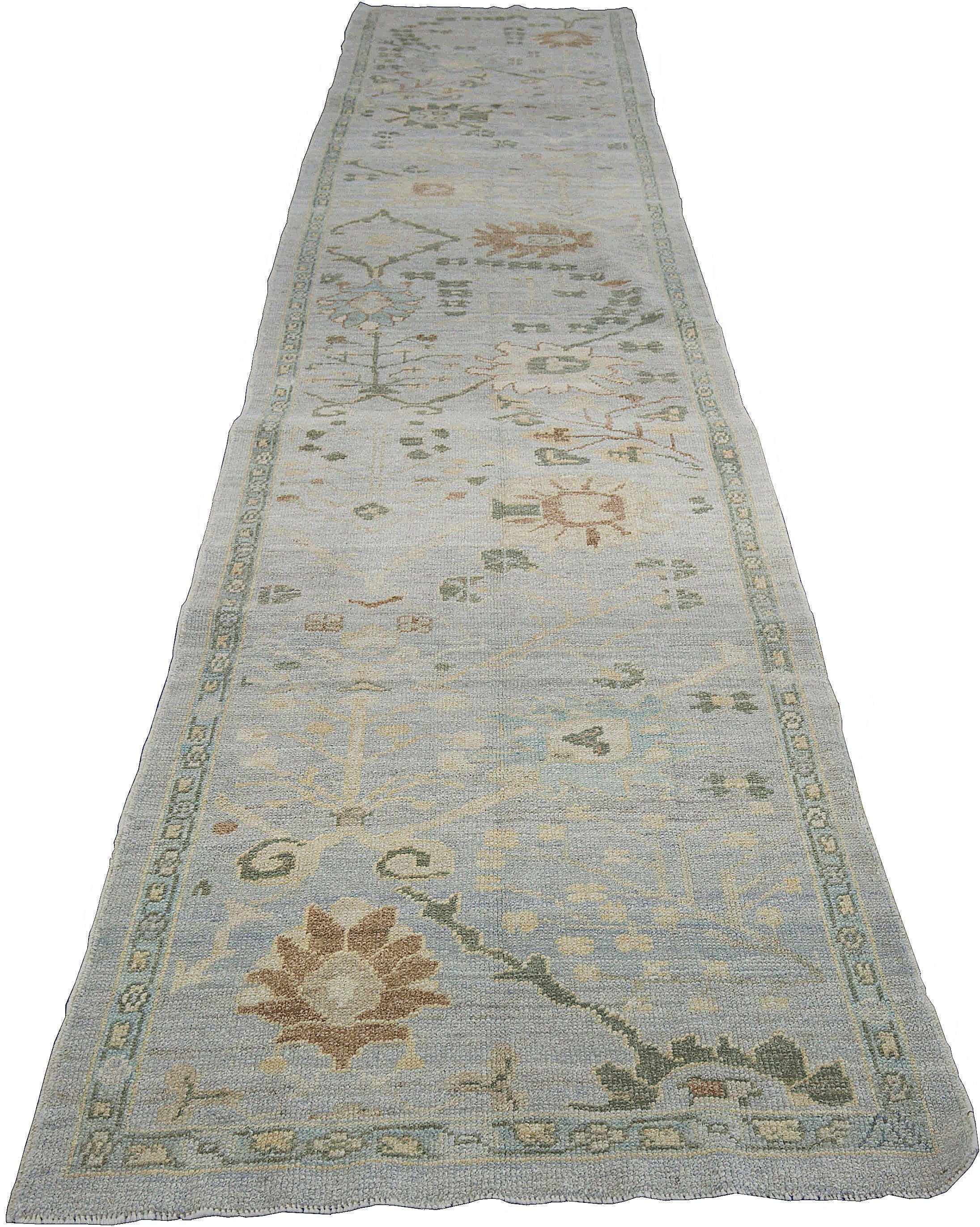 Modern Turkish rug made of handwoven sheep’s wool of the finest quality. It’s colored with organic vegetable dyes that are certified safe for humans and pets alike. It features a lovely gray field with floral details in green, blue, and brown