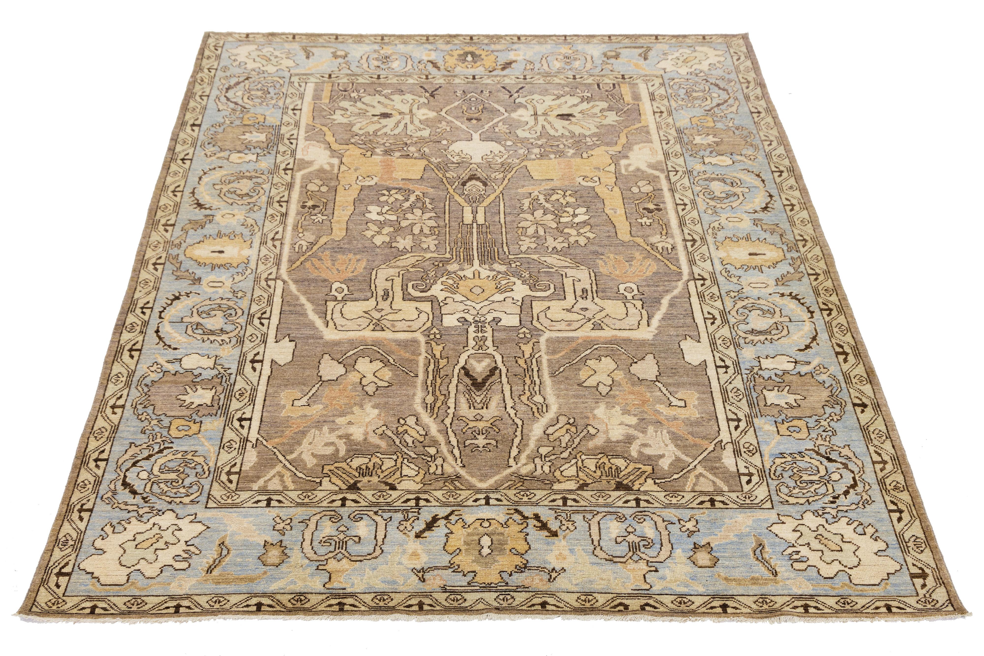 Entdecken Sie die Eleganz dieses modernen, handgeknüpften Wollteppichs im Oushak-Stil, der ein warmes, hellbraunes Feld zeigt, das mit einem komplizierten, floralen Allover-Muster verziert ist. Das Muster wird durch charmante Akzente in Hellbraun,