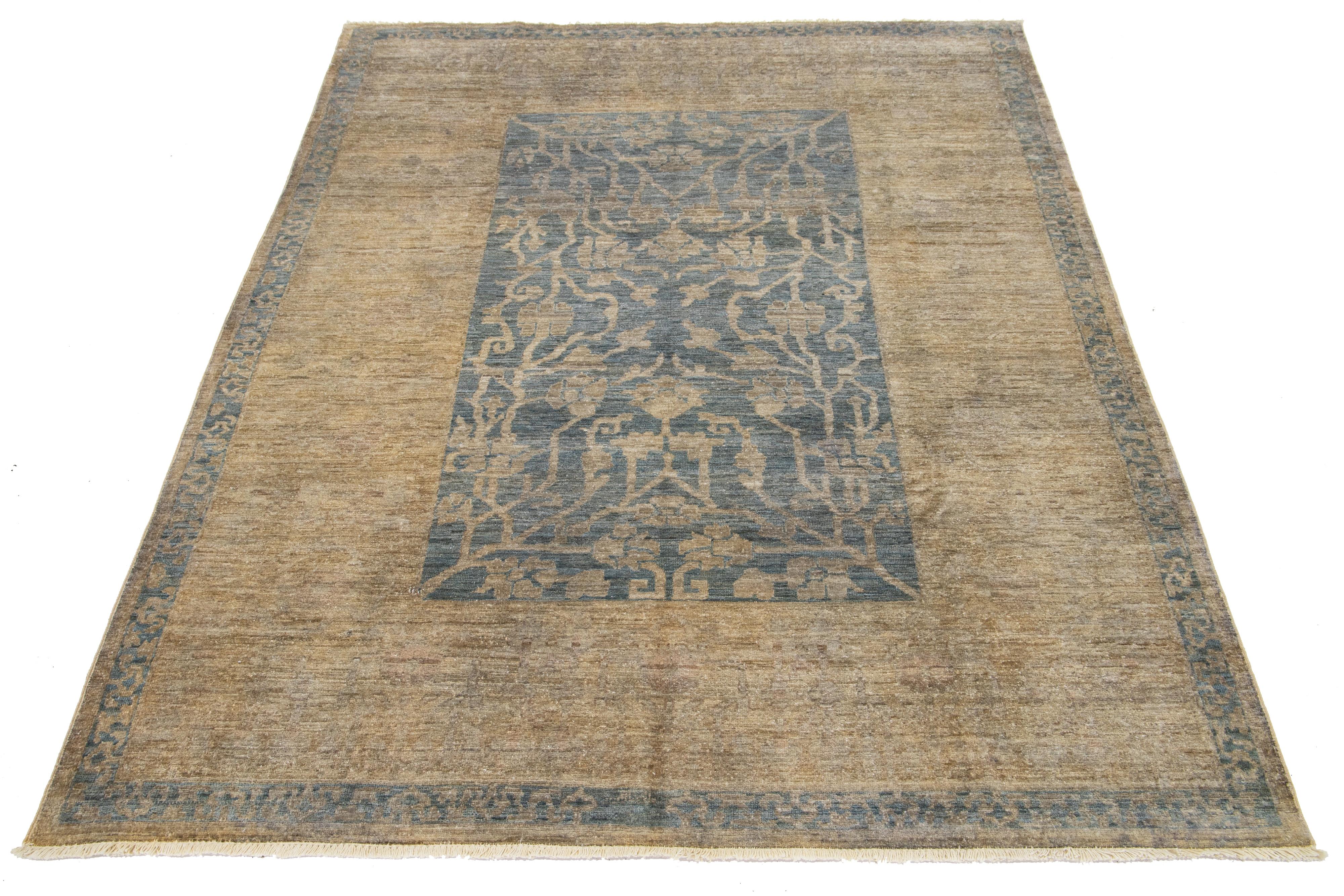 Dieser moderne Wollteppich im Oushak-Stil verbindet zeitgenössisches Design mit dem klassischen Charme der traditionellen Oushak-Handwerkskunst. Es hat einen kräftigen blauen Hintergrund, der mit braunen Blumenmustern verziert ist.

Dieser Teppich