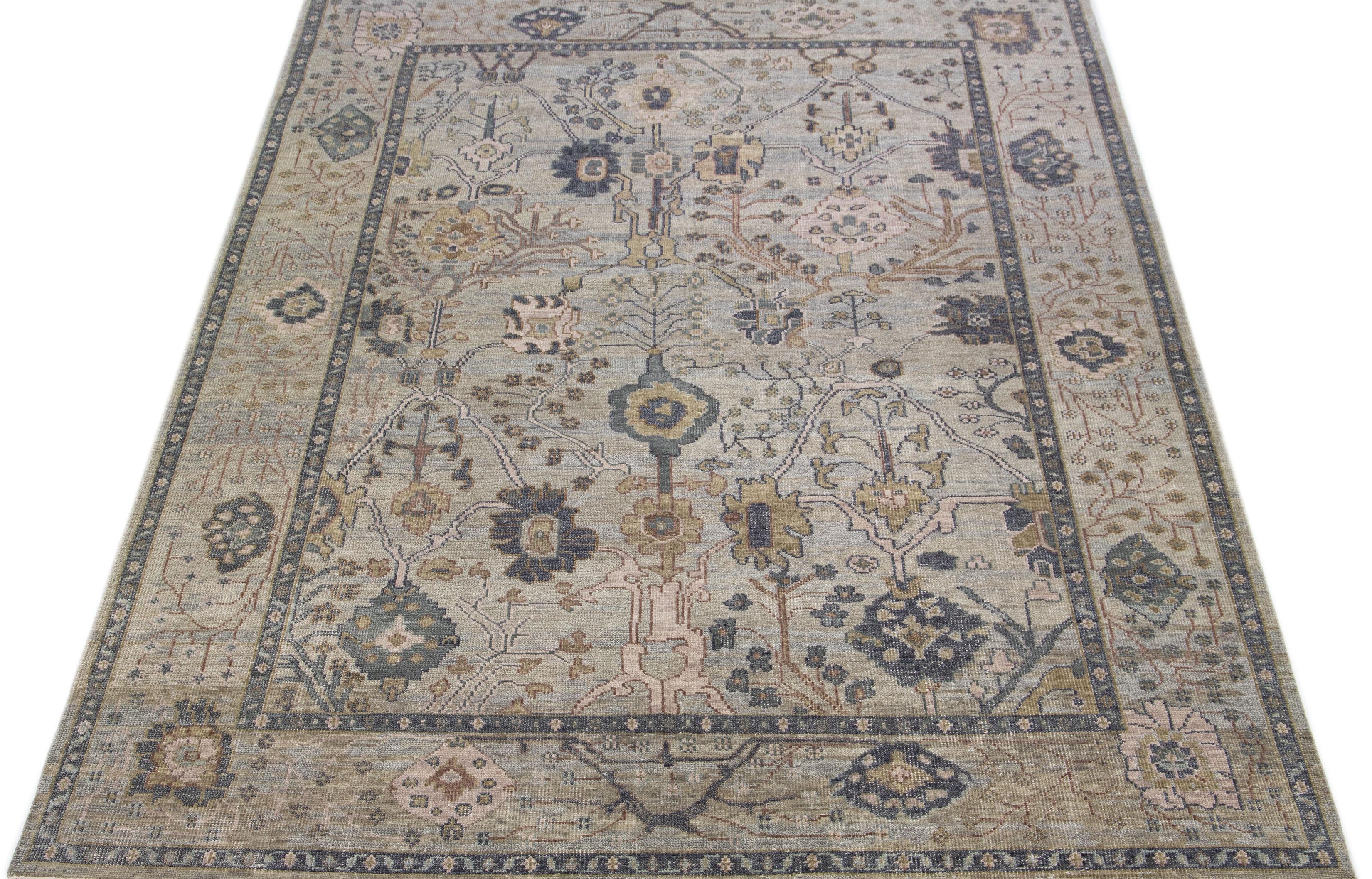 Crafted with great care and attention to detail, this exquisite wool rug in Oushak Style boasts a delightful gray base that exudes elegance. Highlighted with magnificent beige, brown, and navy blue accents, it flaunts a captivating floral design