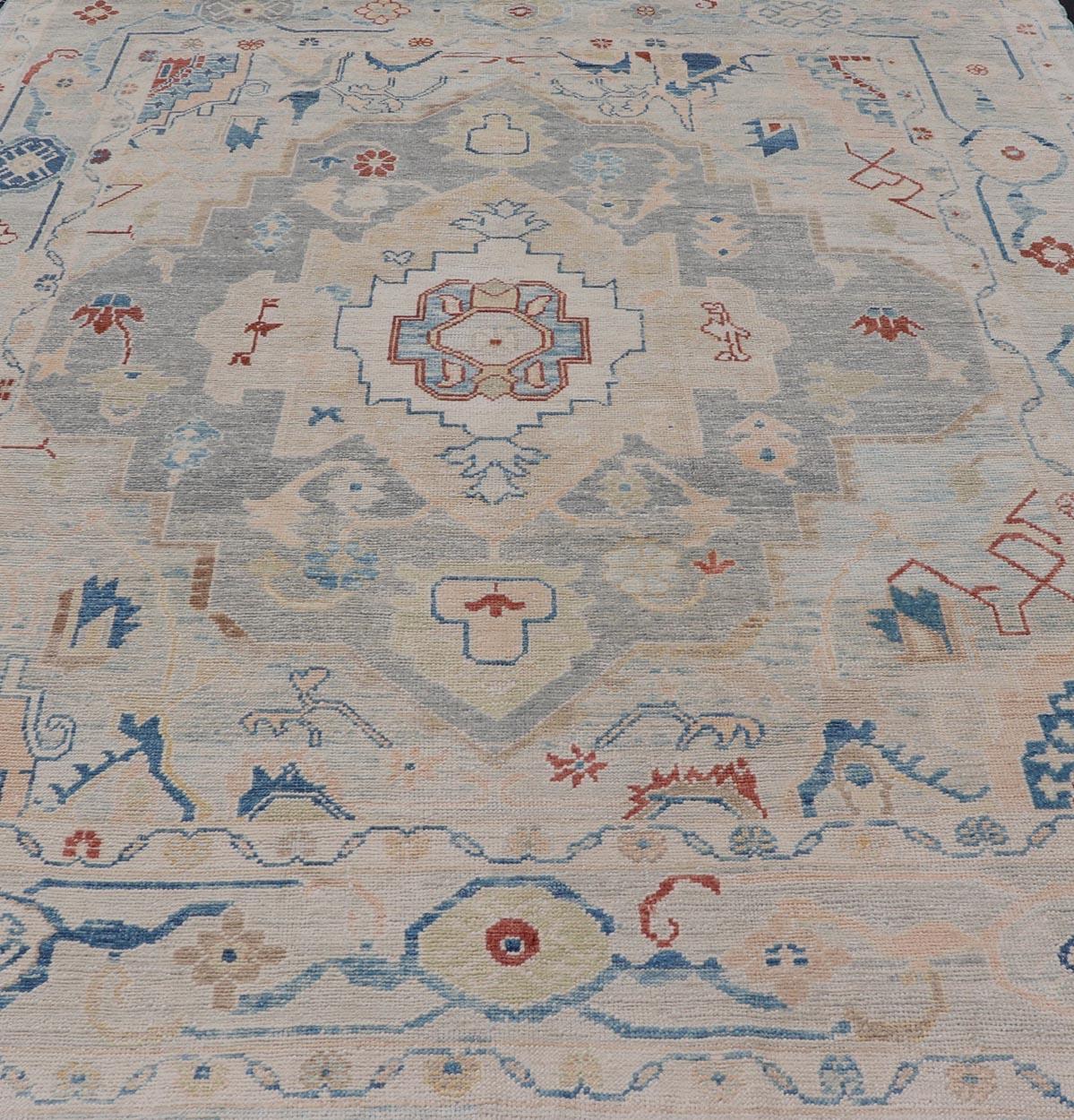 Measures: 8'5 x 11'9 
Modern Oushak Turkish Rug with All Over Design in Light Blue, Ivory, & Red. Keivan Woven Arts / rug EN-15209, country of origin / type: Turkey / Oushak.

This Oushak in geometric medallion design rug was woven in Turkey. Set on