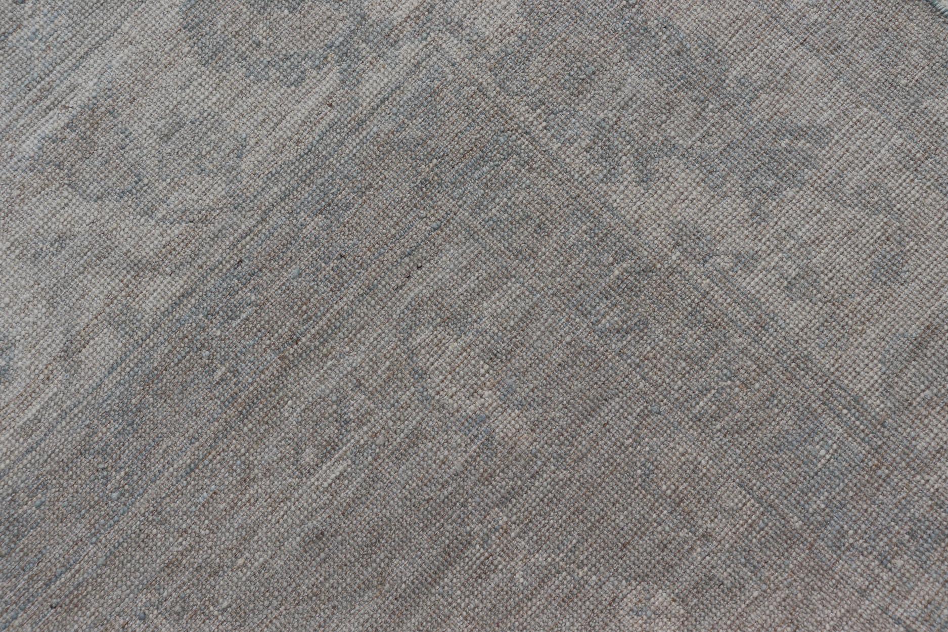 Oushak moderno con fondo azul claro y gris con medallón y motivos tribales en venta 2