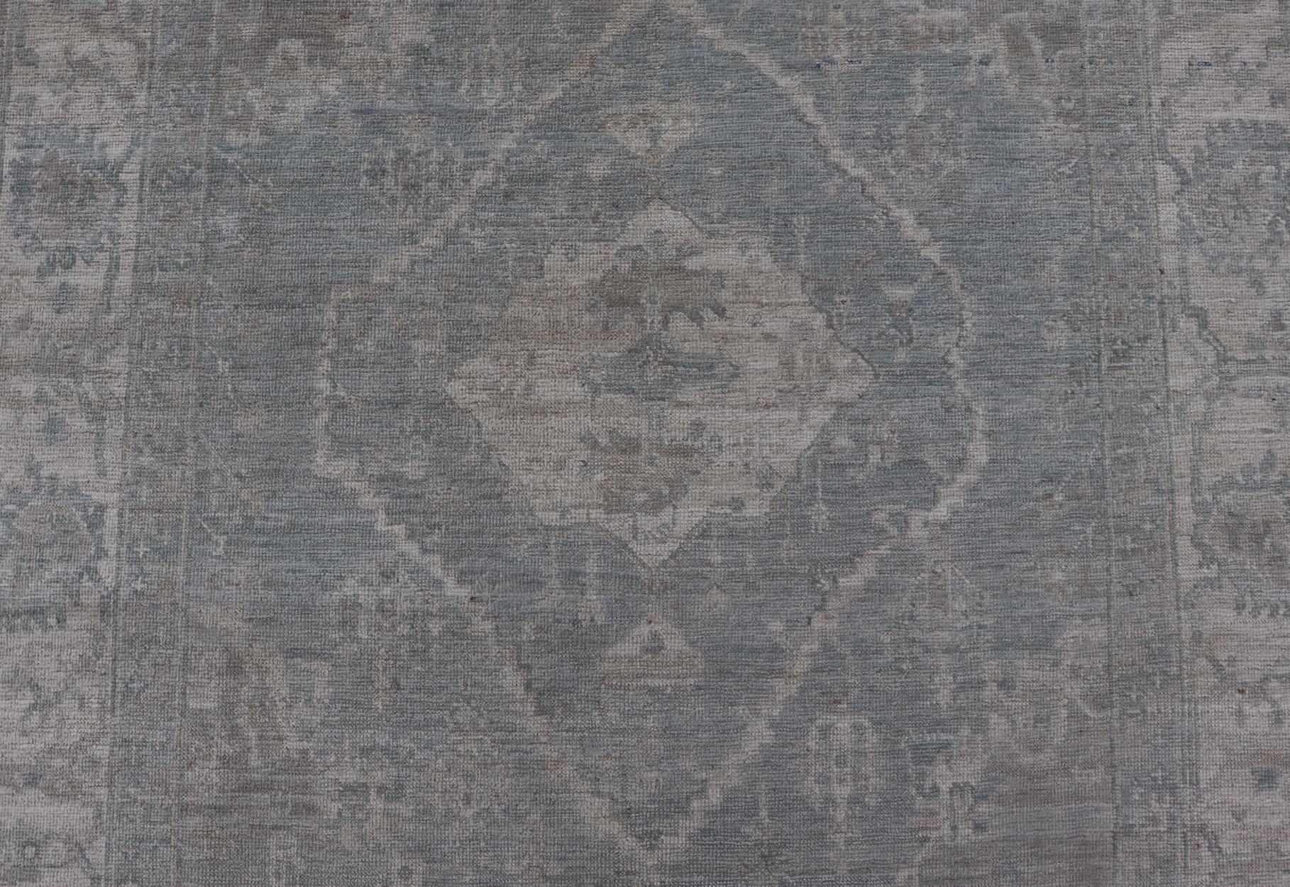 Medidas: 5'10 x 8'9 
Oushak moderno con fondo azul claro y gris con medallón y motivos tribales. País de origen: Afganistán; Tipo: Oushak; Diseño: Medallón, medallón tribal, por todas partes; Keivan Woven Arts: alfombra AWR-12170. Siglo XXI. 
Este