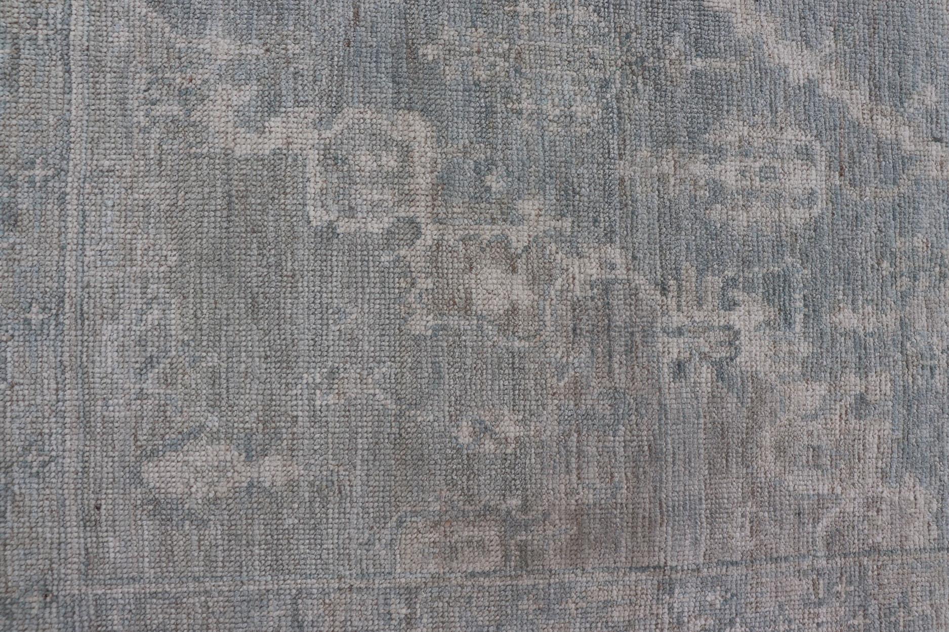 Oushak moderno con fondo azul claro y gris con medallón y motivos tribales en Nuevo estado para la venta en Atlanta, GA
