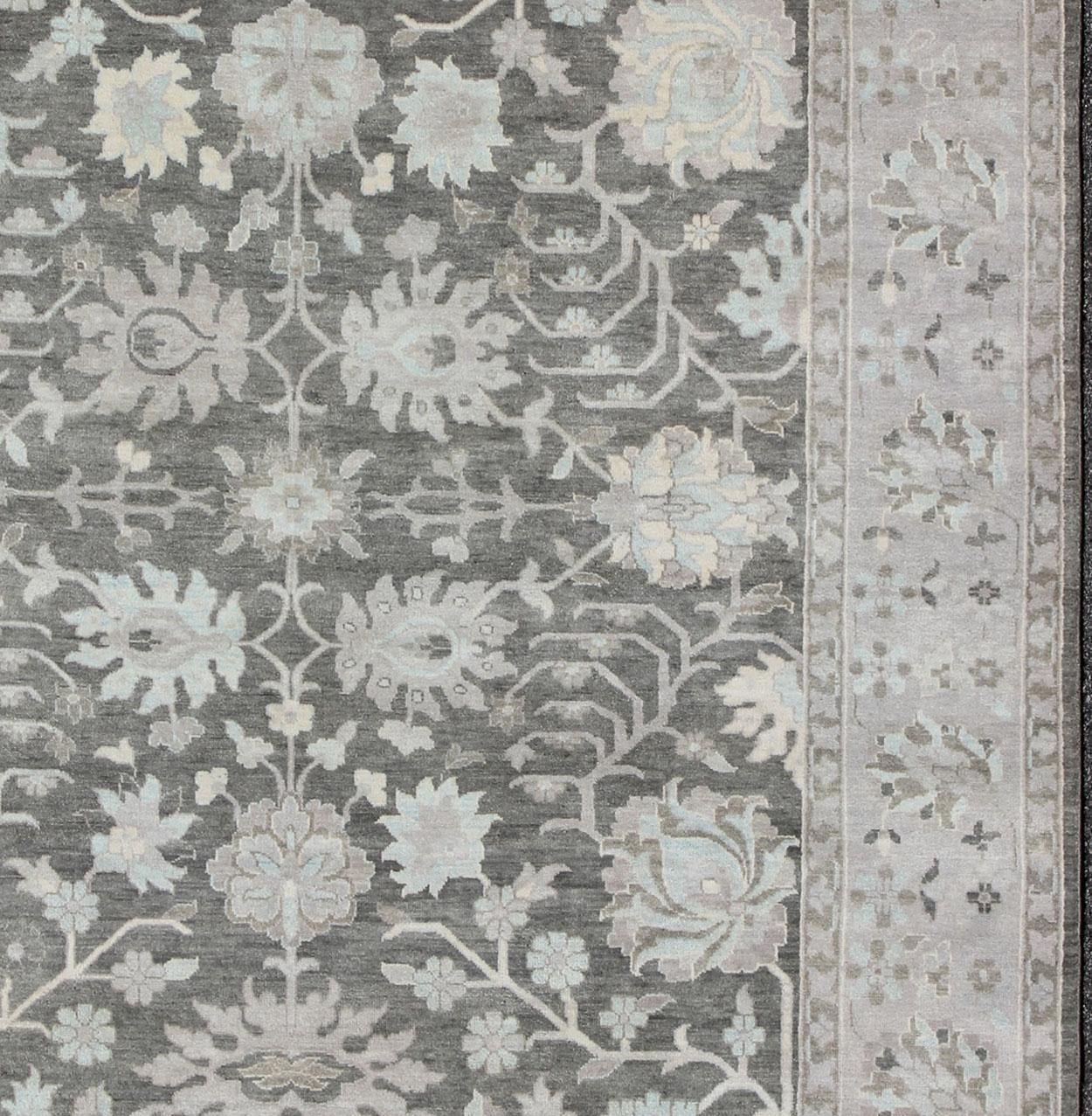 Questo bellissimo Oushak floreale è ancorato da uno sfondo grigio e da un bordo color taupe, tappeto Keivan Woven Arts OB-9288503-271010, paese d'origine/tipo: India / Oushak, circa inizio XXI secolo. 

Misure: 9'8 x 13'2.

Il design di questo