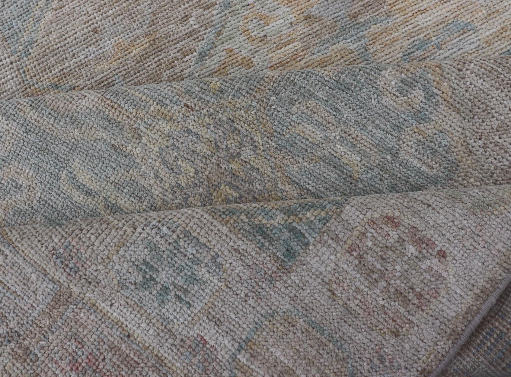 Moderner Oushak mit heller Koralle und blauen Motiven auf hellem taupefarbenem Hintergrund im Angebot 5